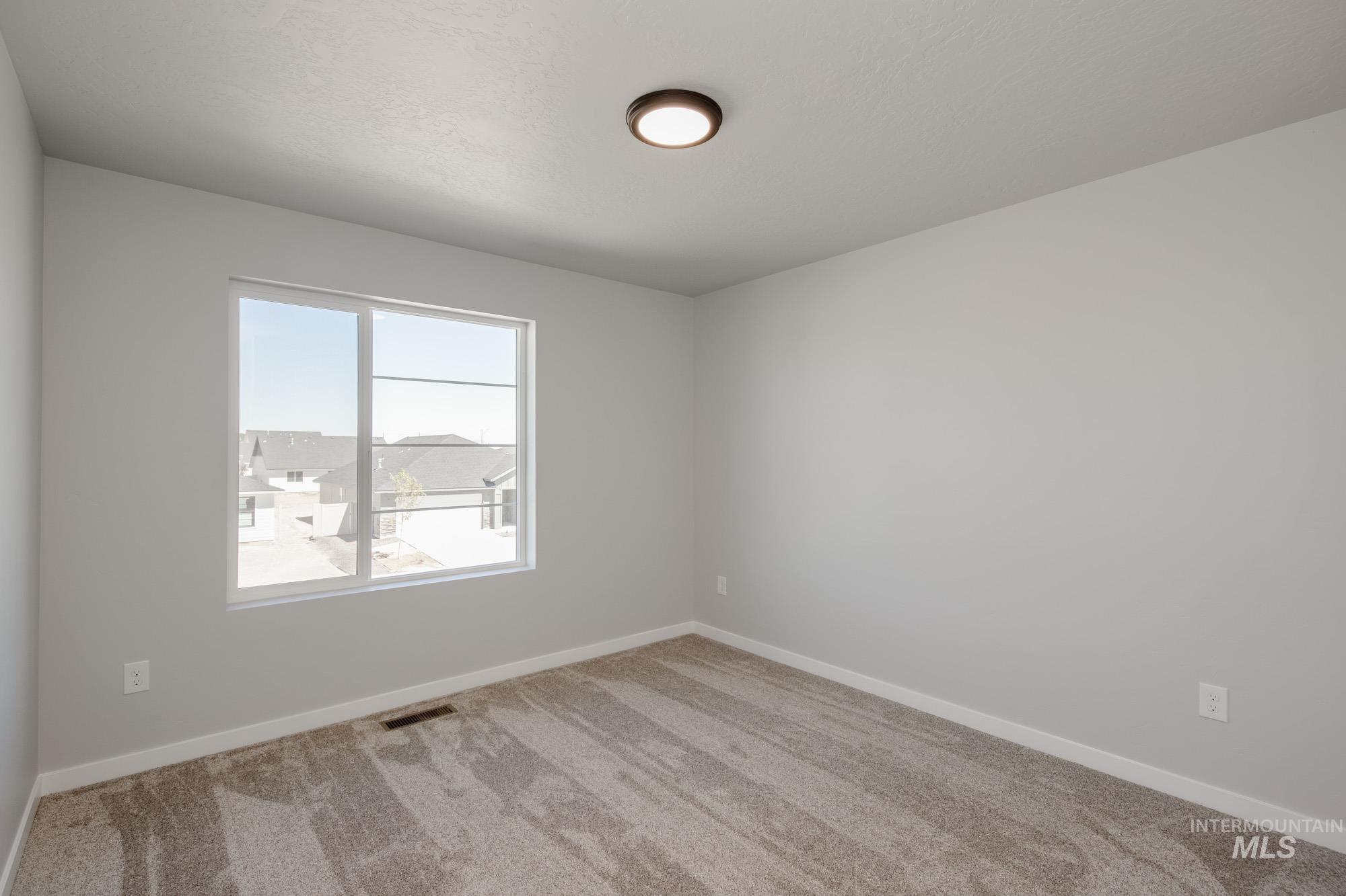 Carpeted empty room with baseboards