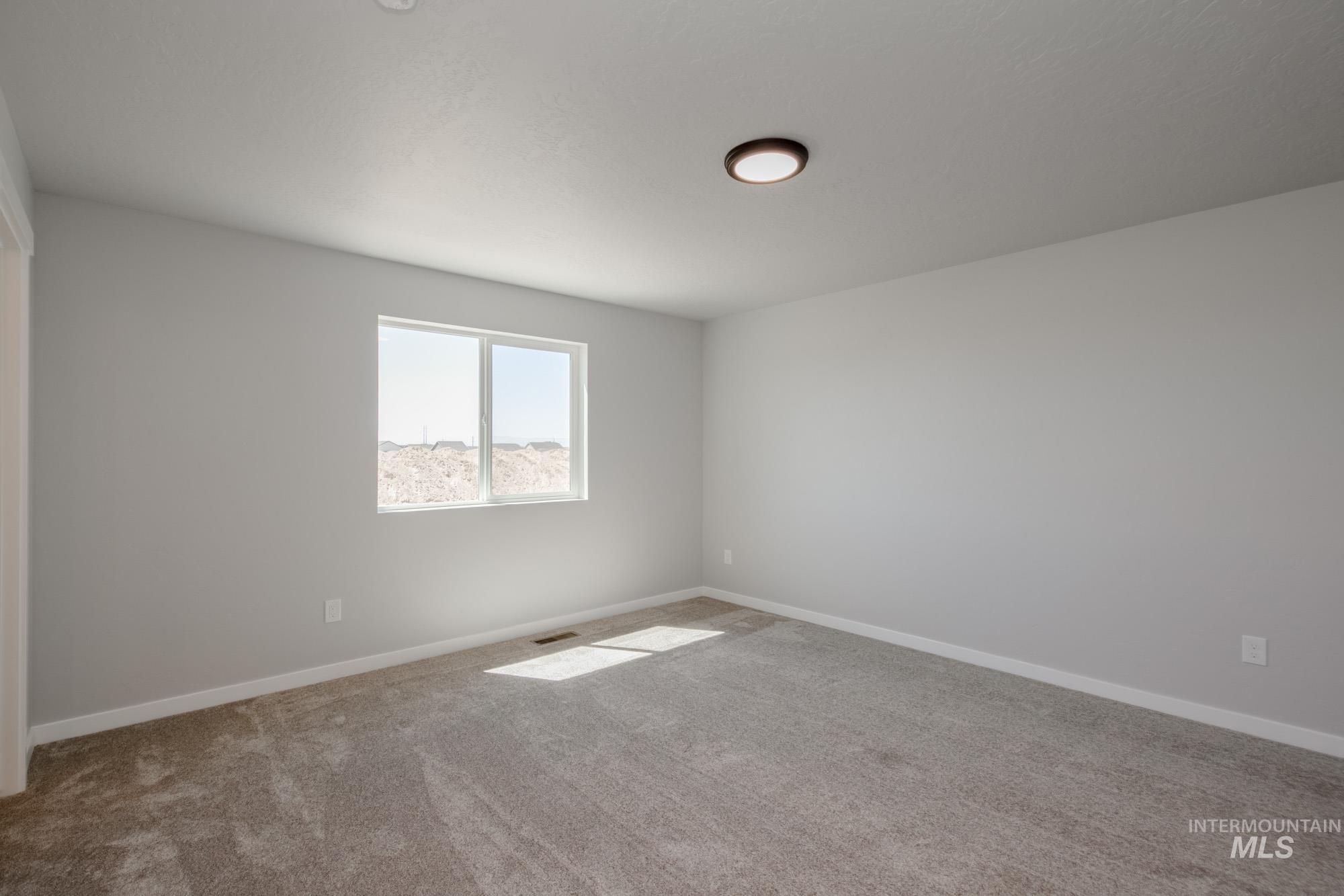 Carpeted empty room with baseboards
