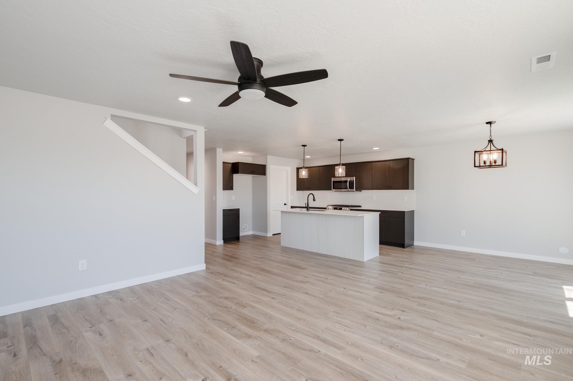 Unfurnished living room featuring ceiling fan, light wood-style flooring, and recessed lighting