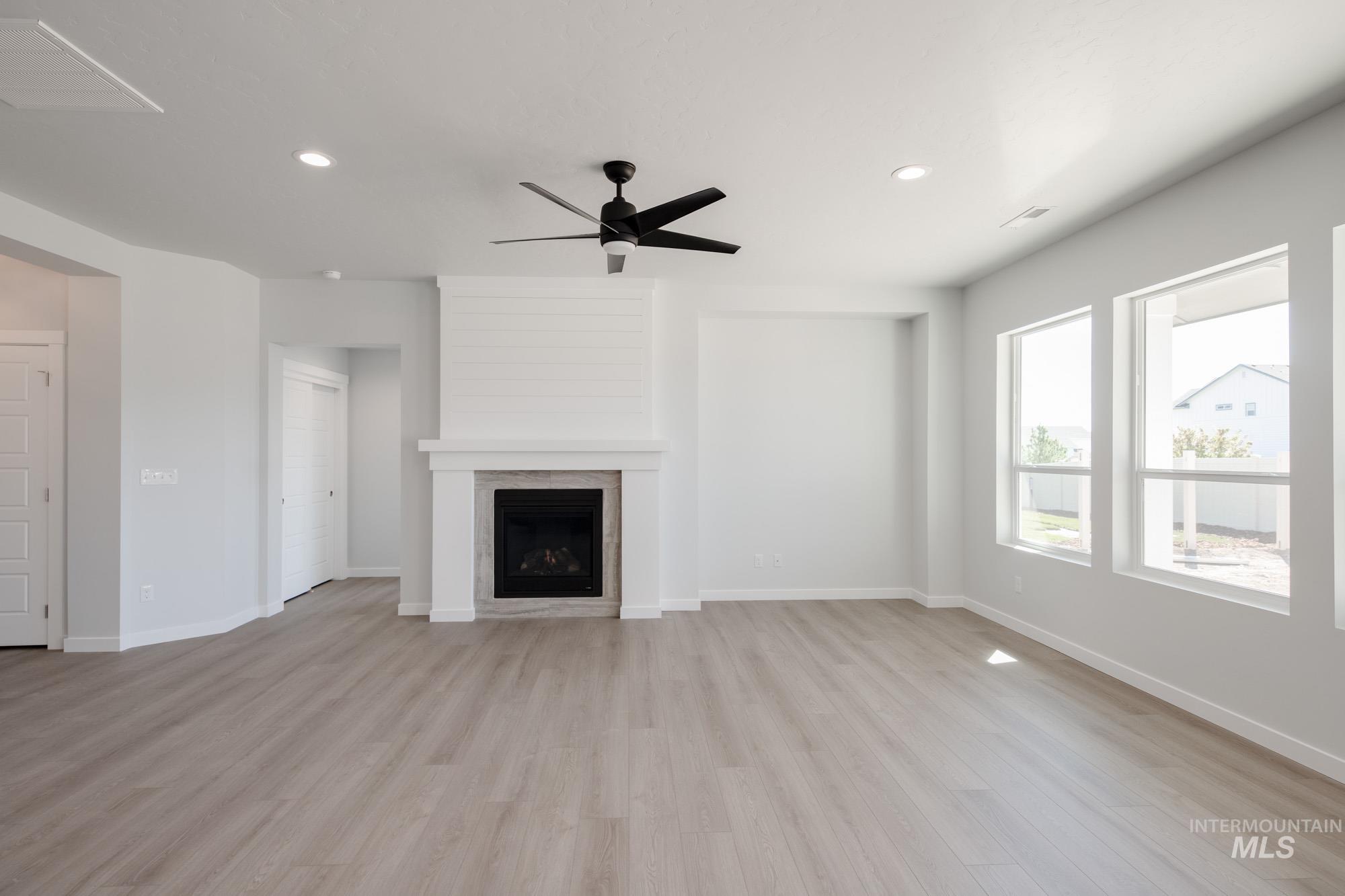 Unfurnished living room featuring light wood-style flooring, recessed lighting, ceiling fan, and a fireplace