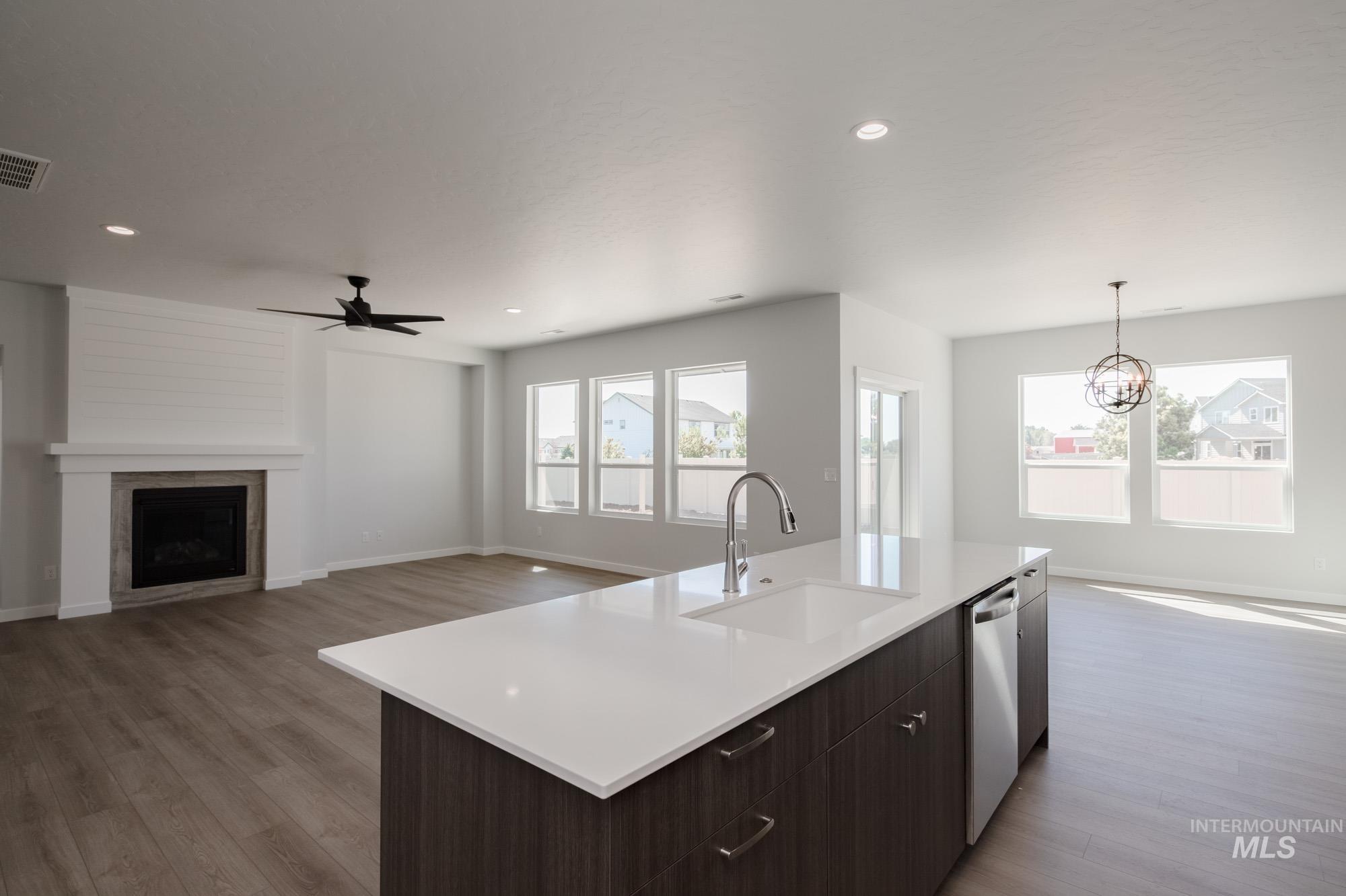 Kitchen featuring open floor plan, dark brown cabinetry, plenty of natural light, light wood-style floors, and recessed lighting