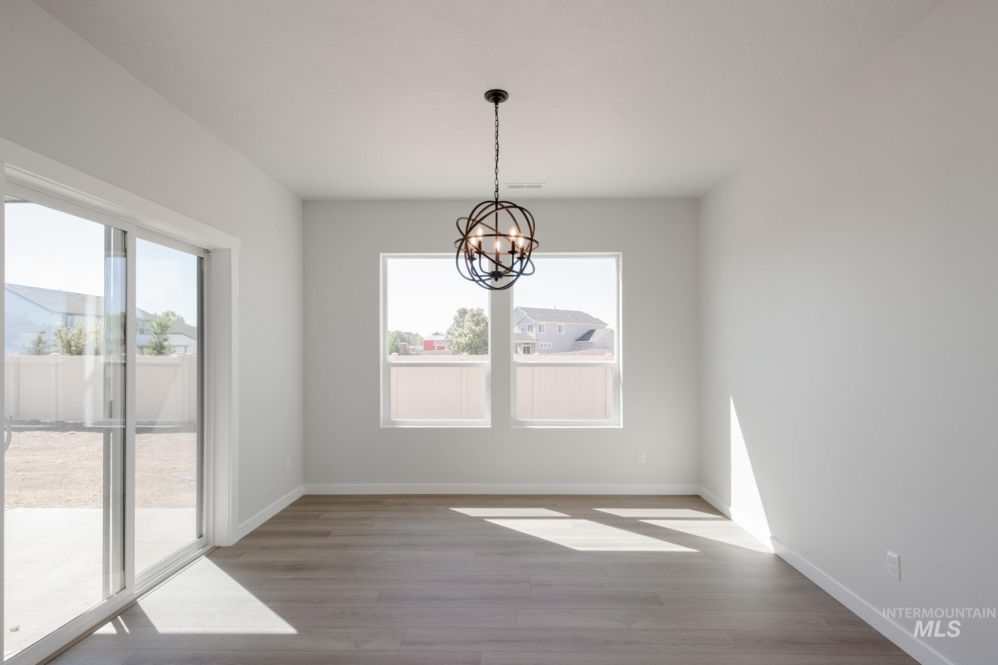 Unfurnished dining area featuring a chandelier and light wood finished floors