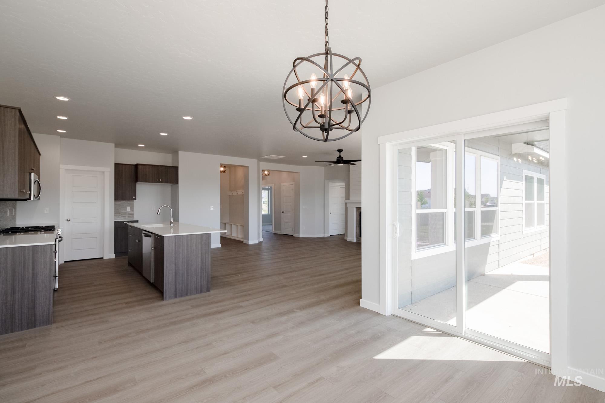 Kitchen featuring light wood-style flooring, stainless steel appliances, open floor plan, a chandelier, and recessed lighting
