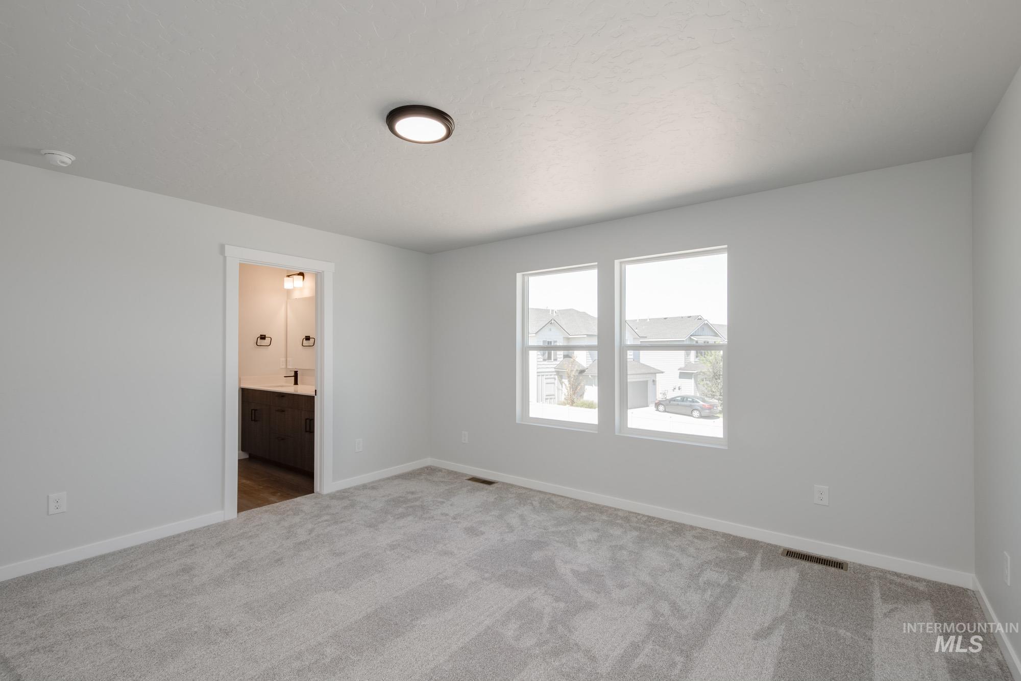 Spare room with carpet and baseboards