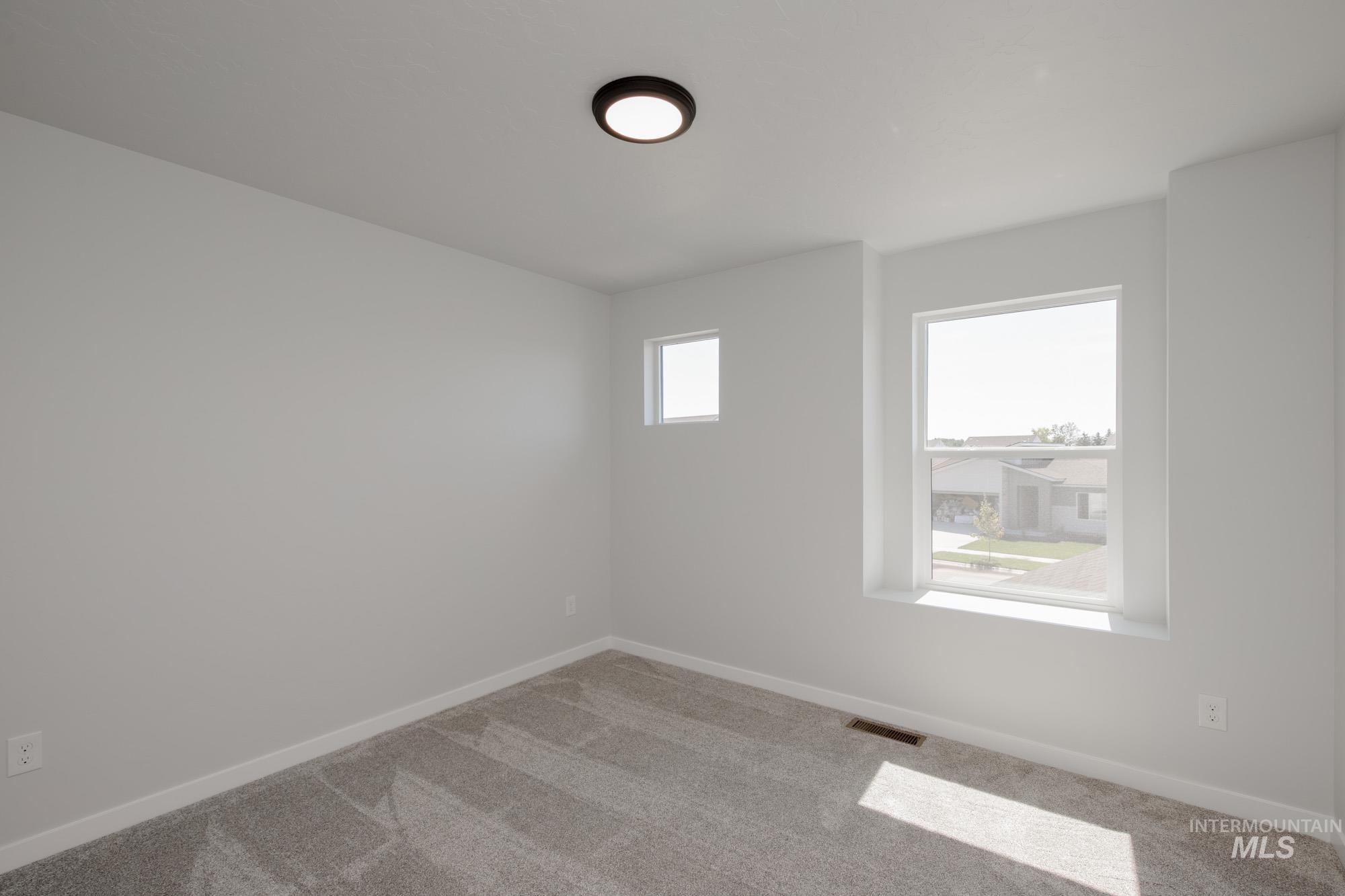 Spare room with baseboards and carpet