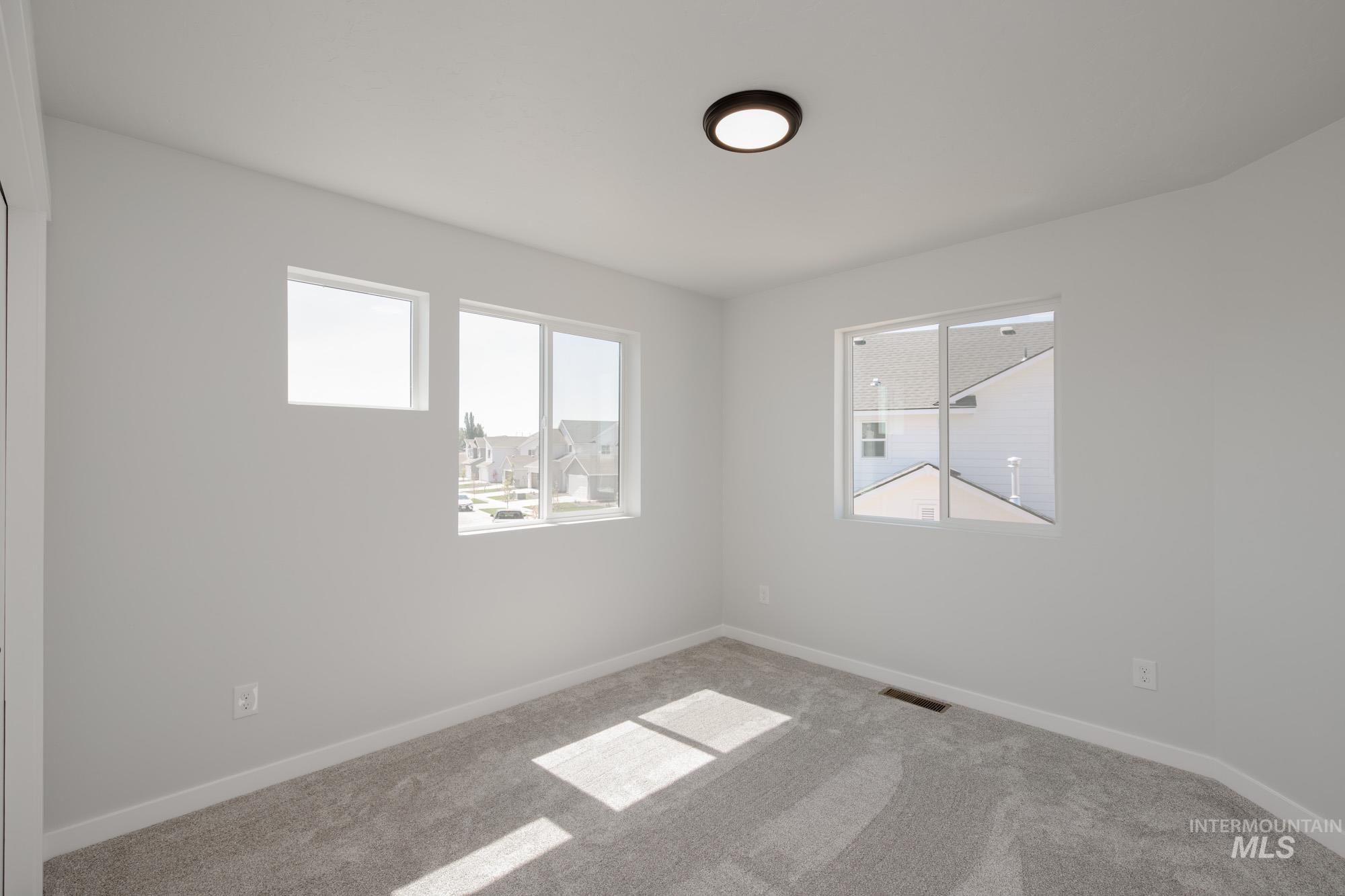 Carpeted spare room with baseboards