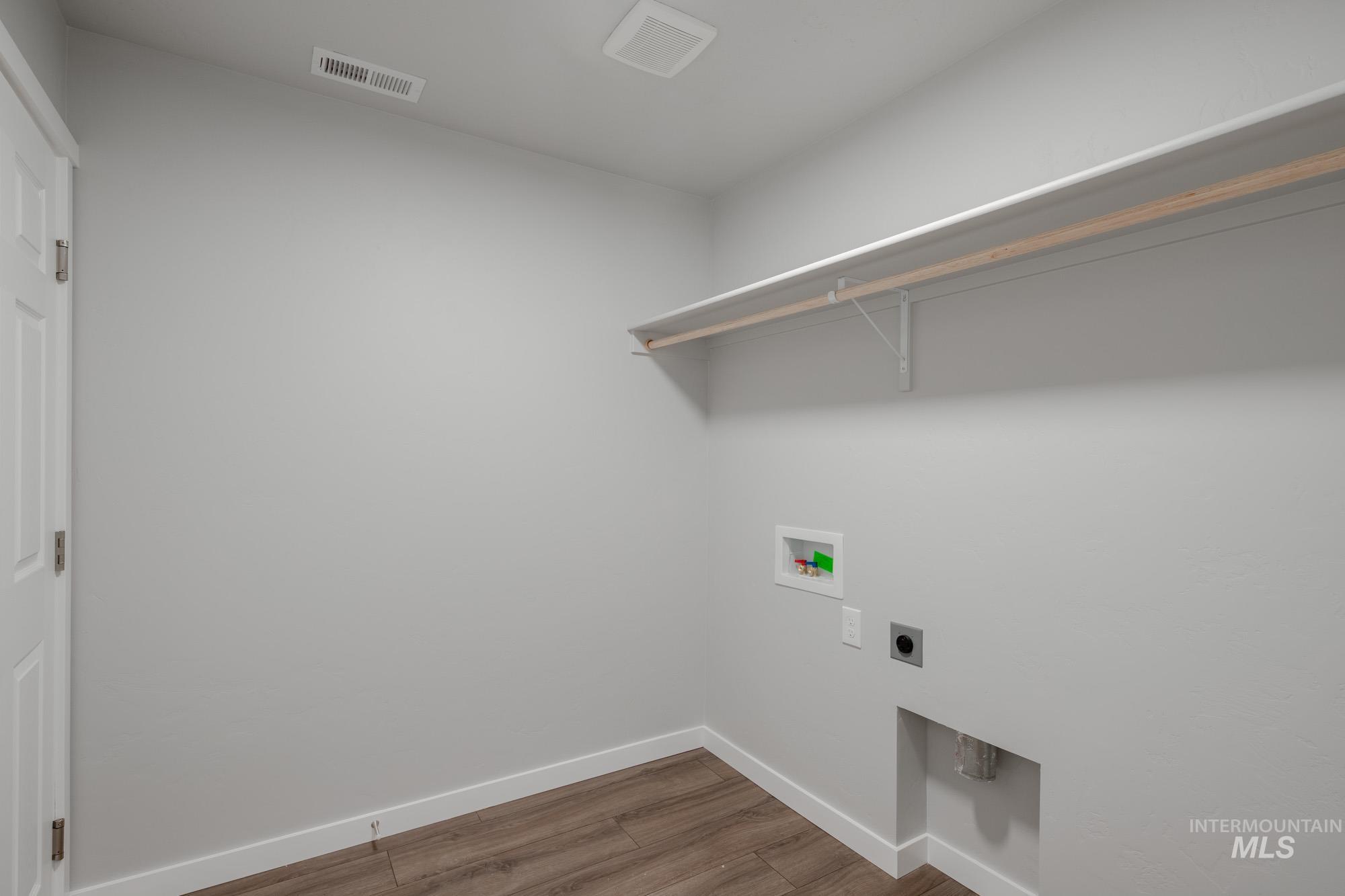 Laundry room featuring light wood-type flooring, washer hookup, and hookup for an electric dryer