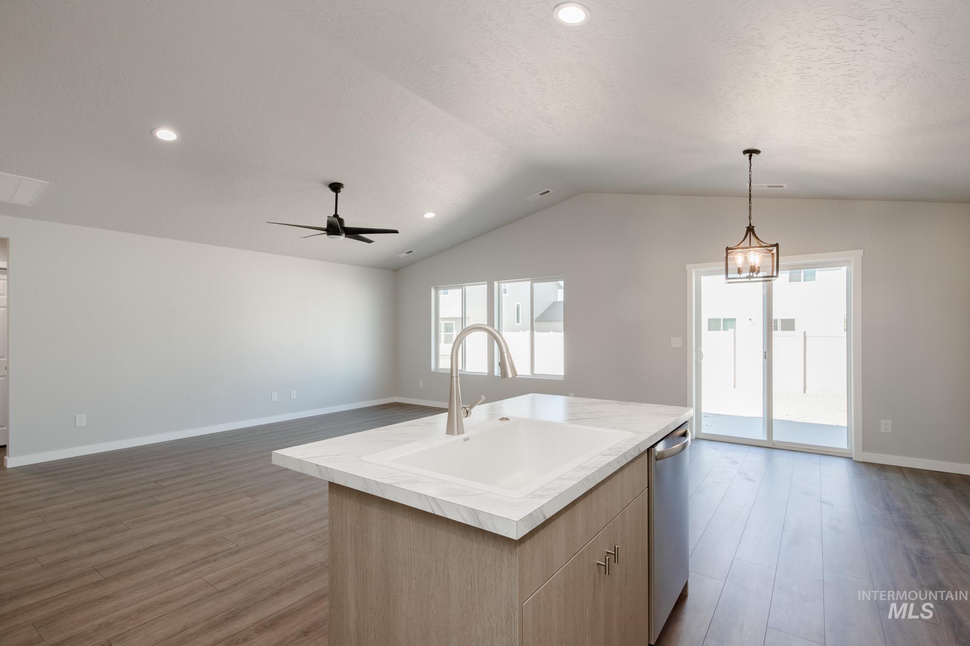 Kitchen featuring light wood-style flooring, light countertops, open floor plan, hanging light fixtures, and recessed lighting