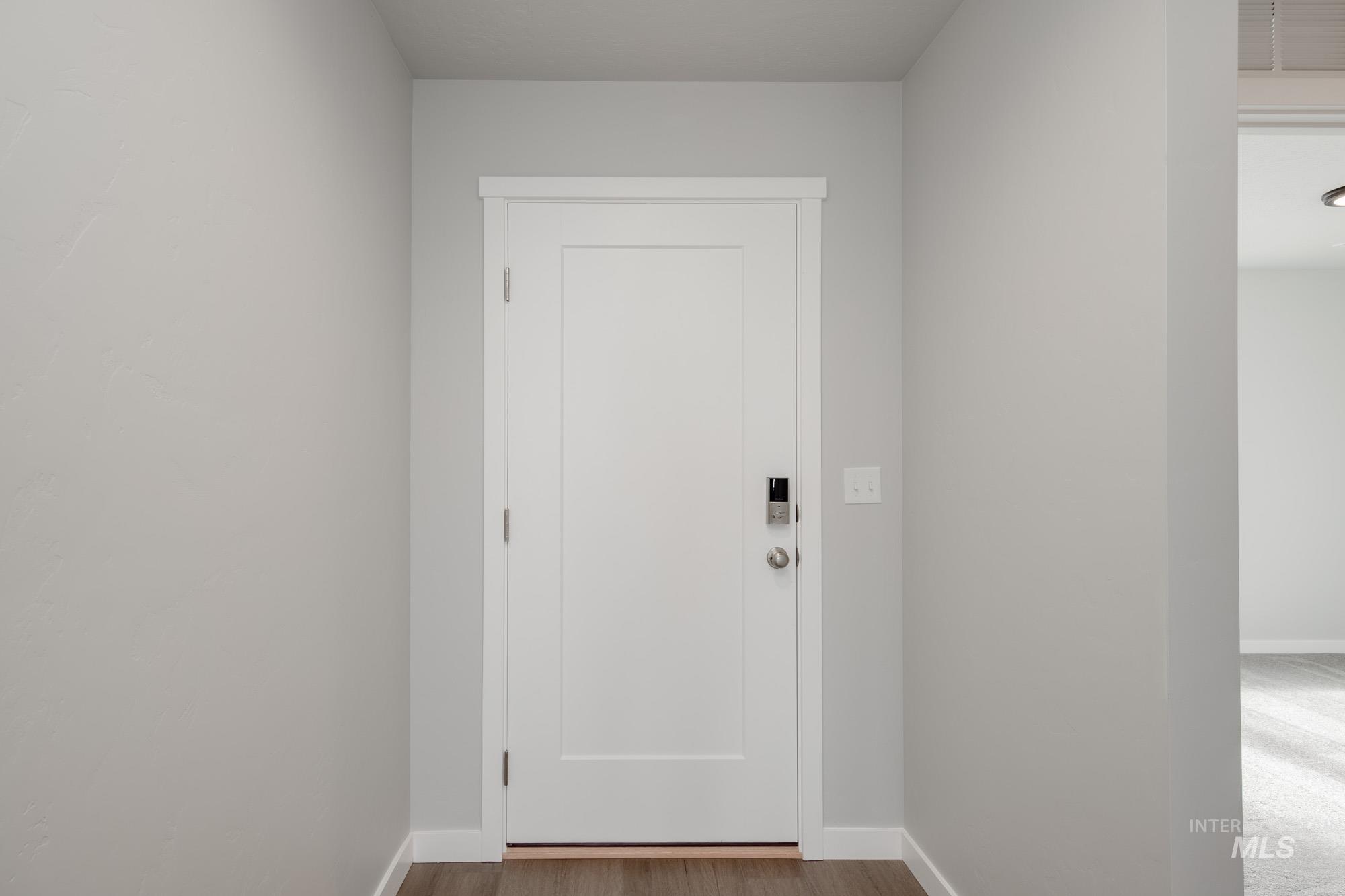 Doorway featuring baseboards and wood finished floors