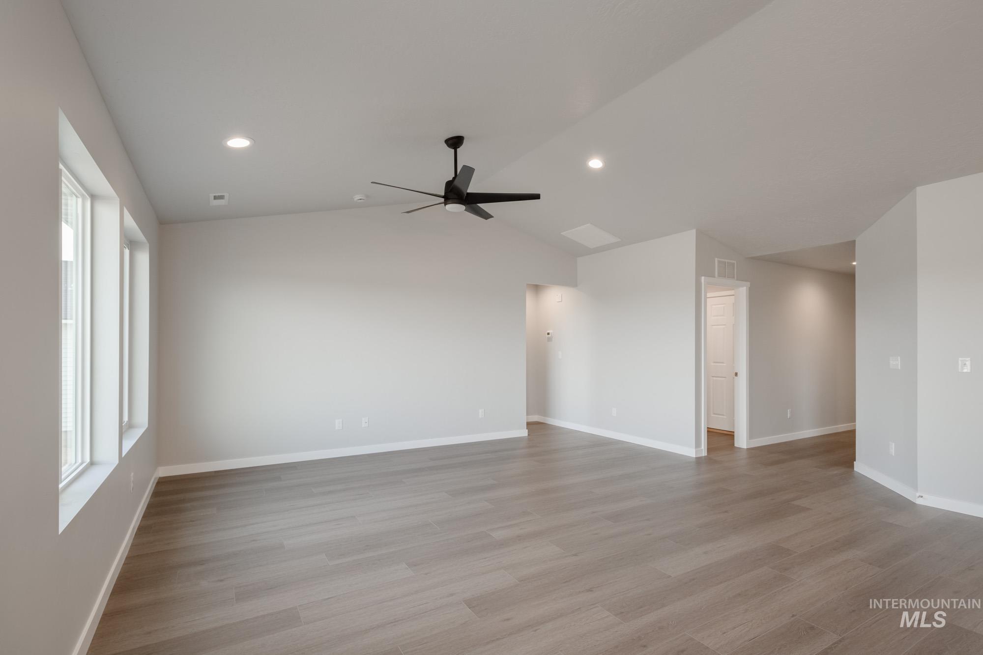 Spare room with lofted ceiling, light wood-style floors, recessed lighting, and a ceiling fan