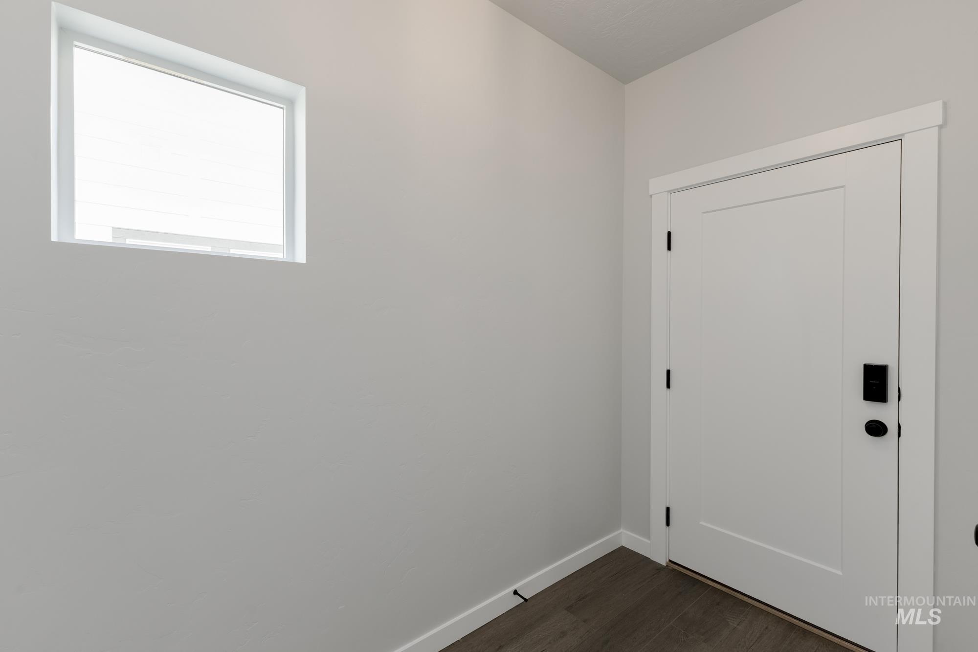 Entryway featuring baseboards and wood finished floors