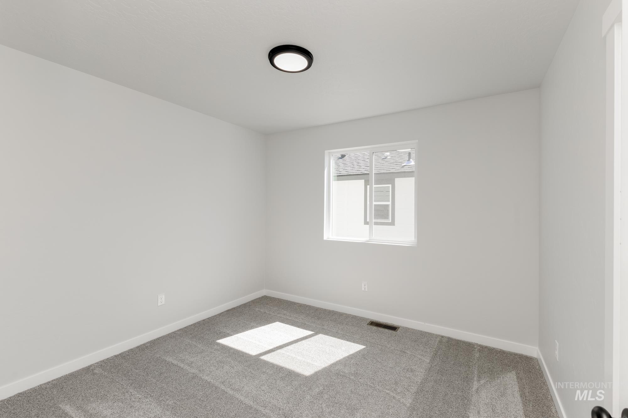 Spare room featuring carpet floors and baseboards