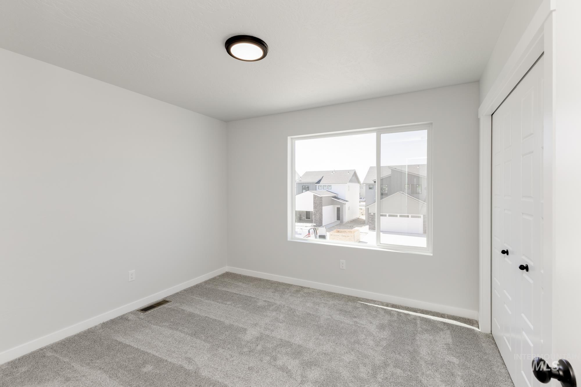 Unfurnished bedroom featuring a closet, carpet, and a residential view