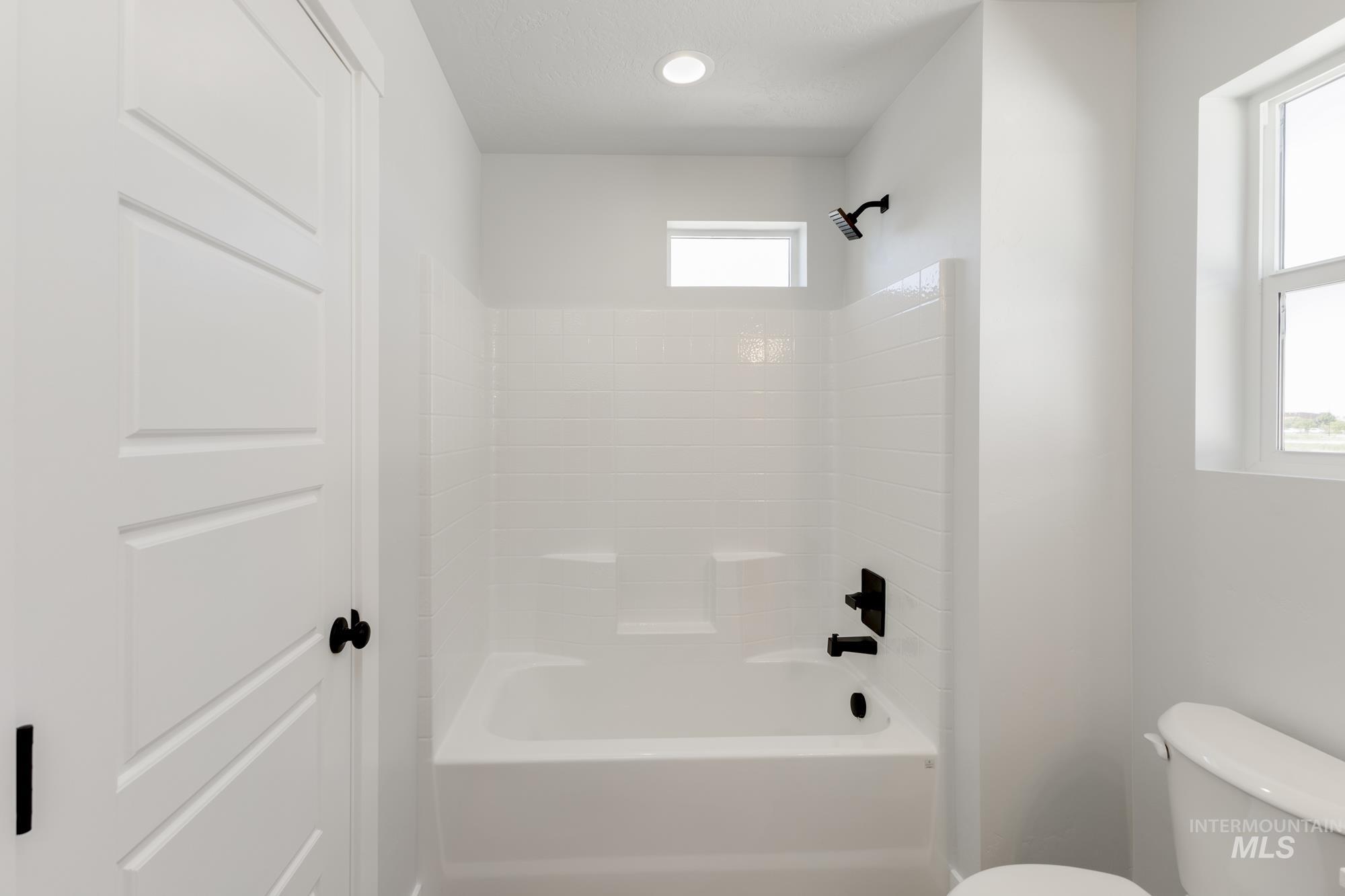 Bathroom featuring toilet and shower / tub combination