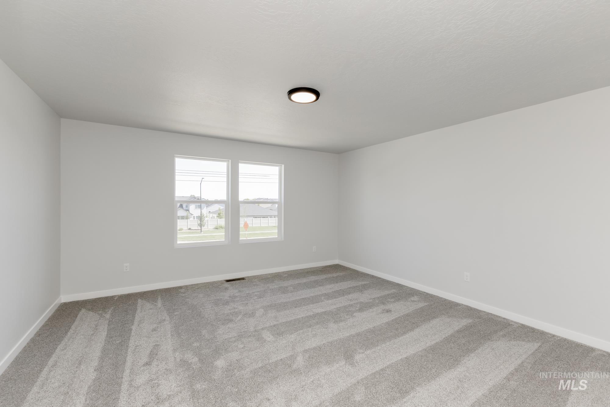 Spare room with light colored carpet and baseboards