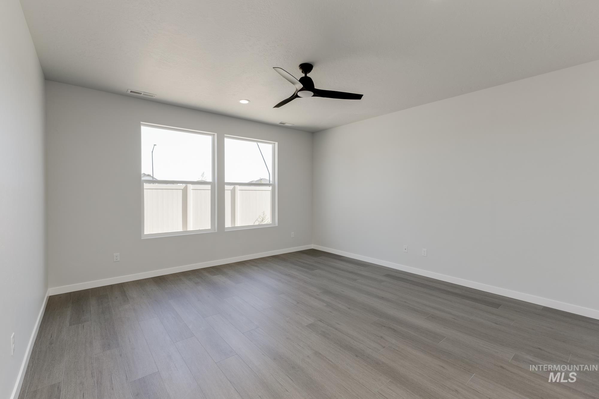 Spare room featuring light wood finished floors, ceiling fan, and recessed lighting