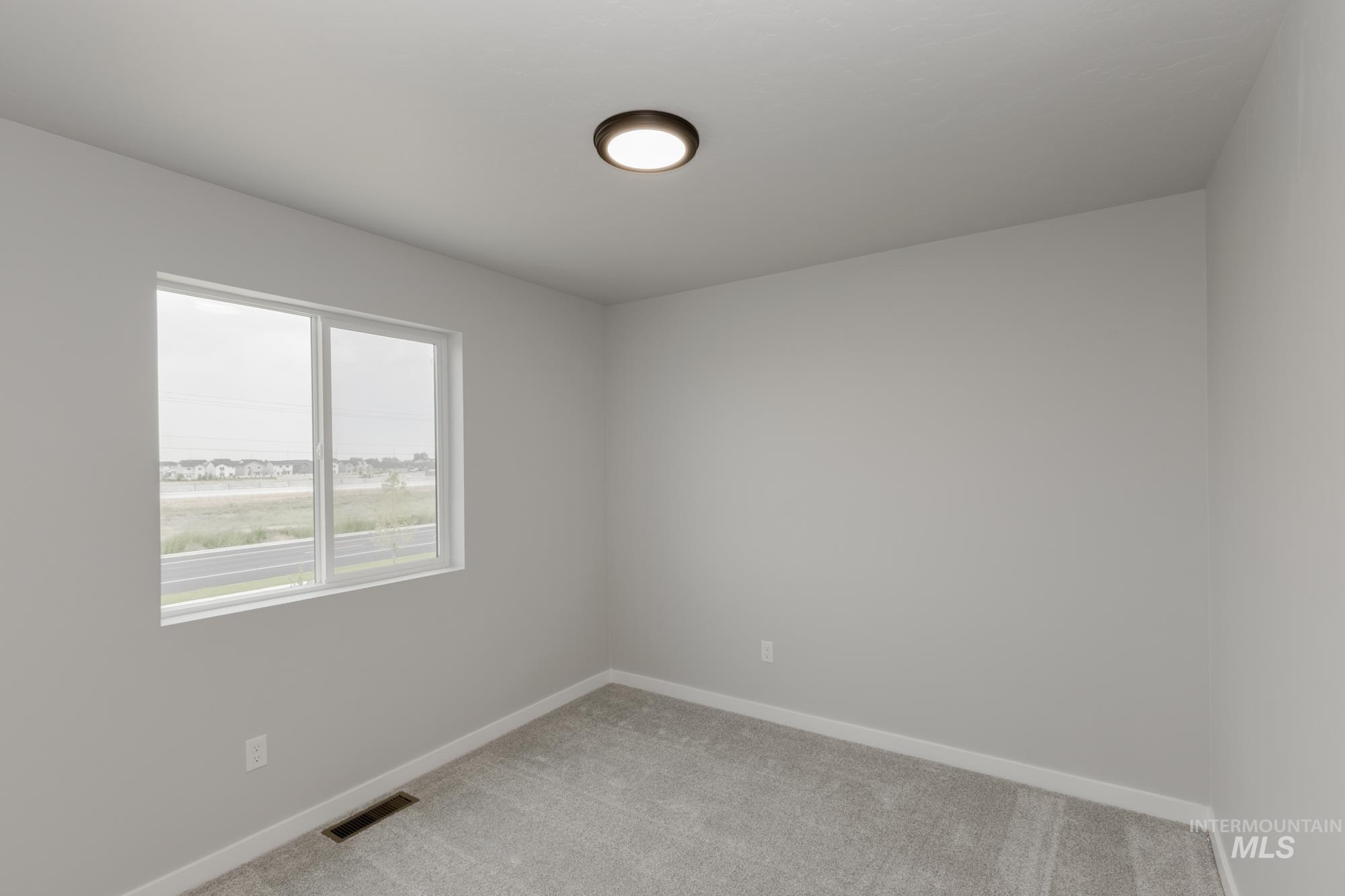 Empty room with carpet floors and baseboards