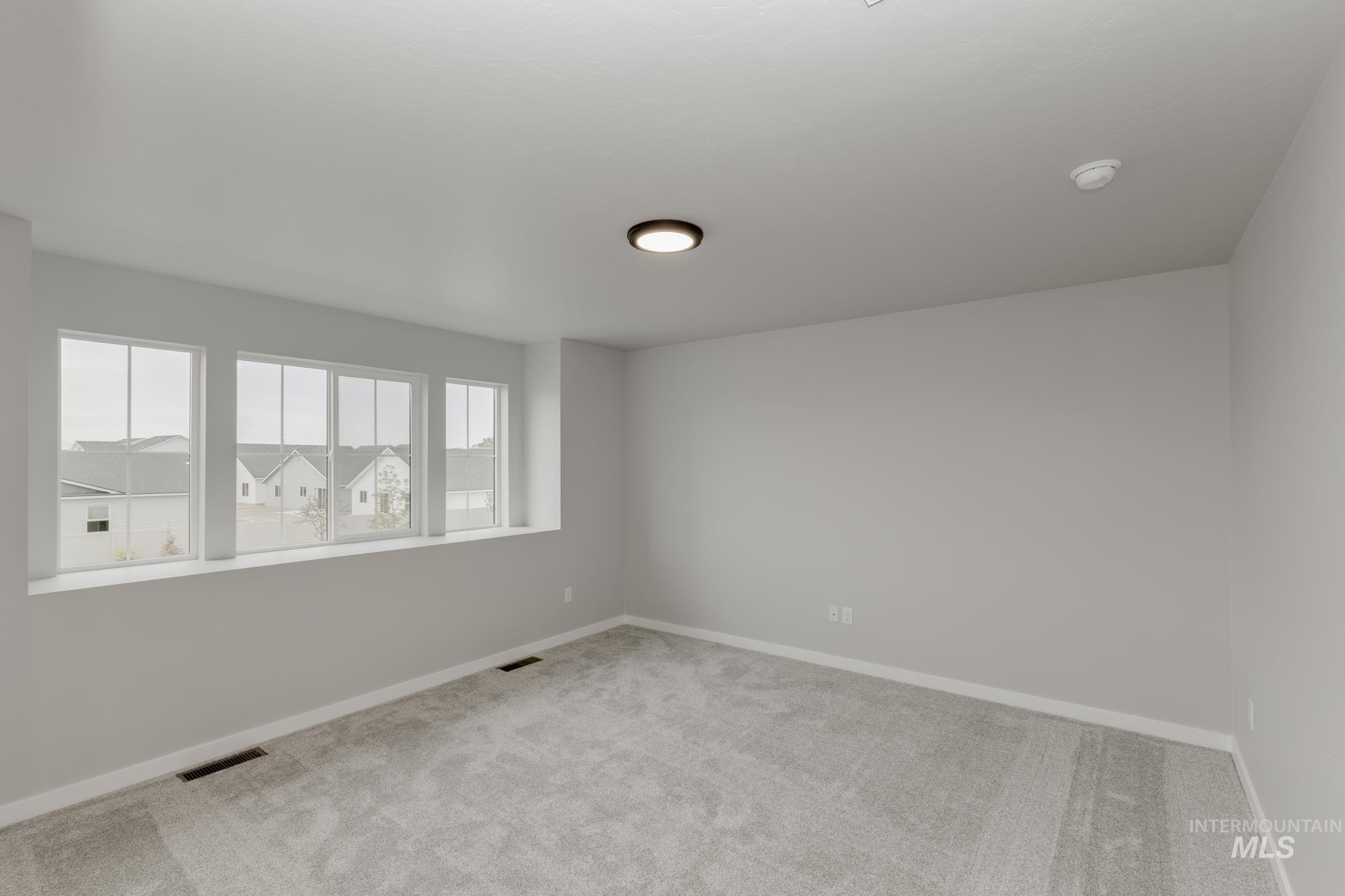 Carpeted empty room with baseboards