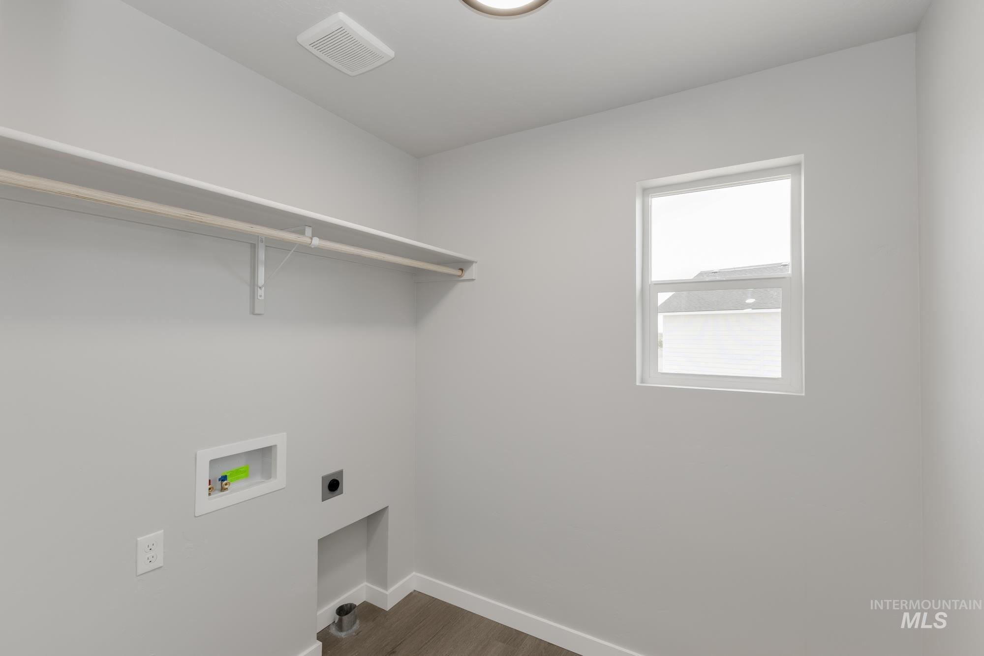 Laundry area with dark wood-style floors, electric dryer hookup, and washer hookup