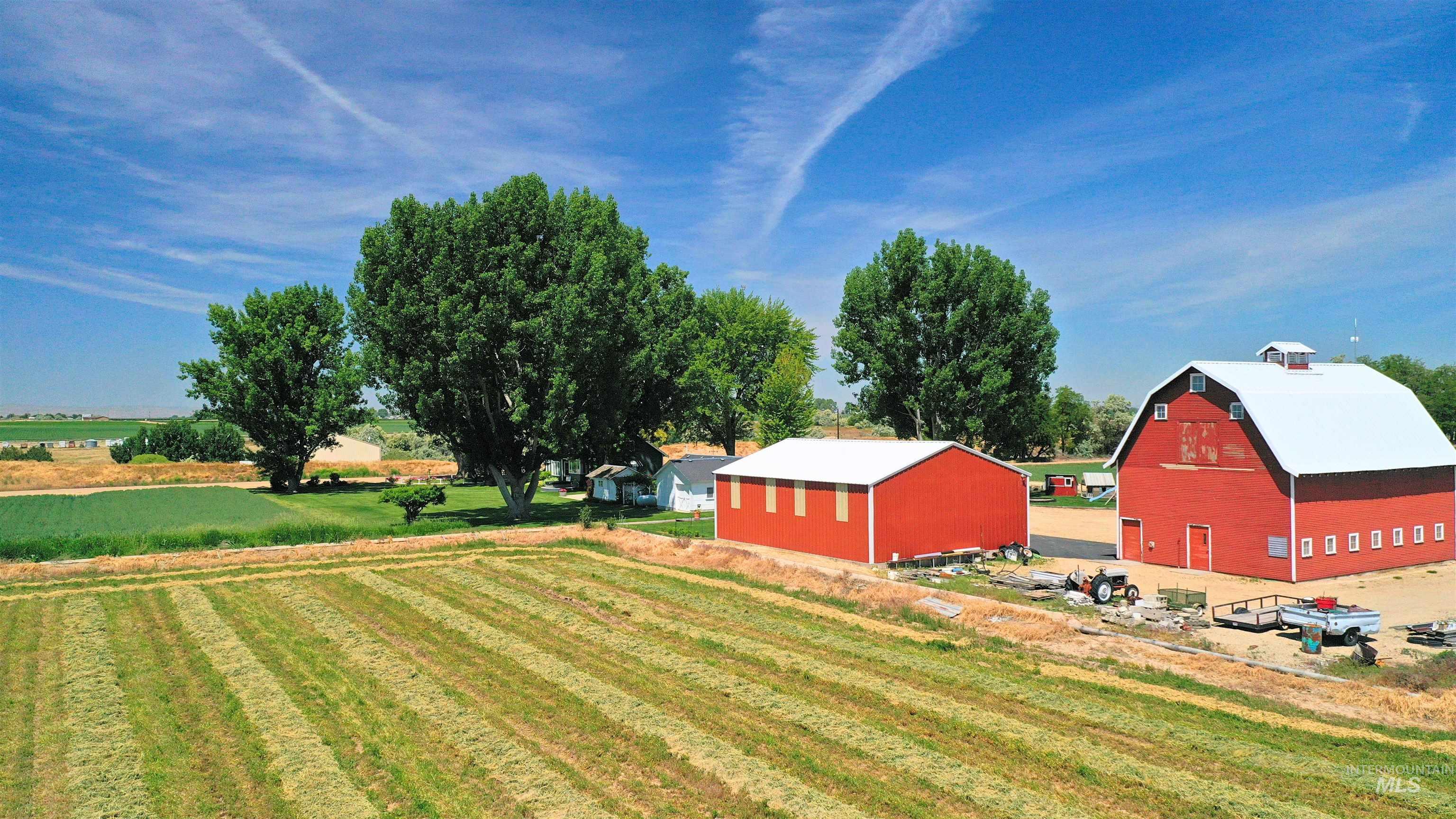 View of green lawn featuring a barn, an outdoor structure, a view of countryside, and agricultural plots