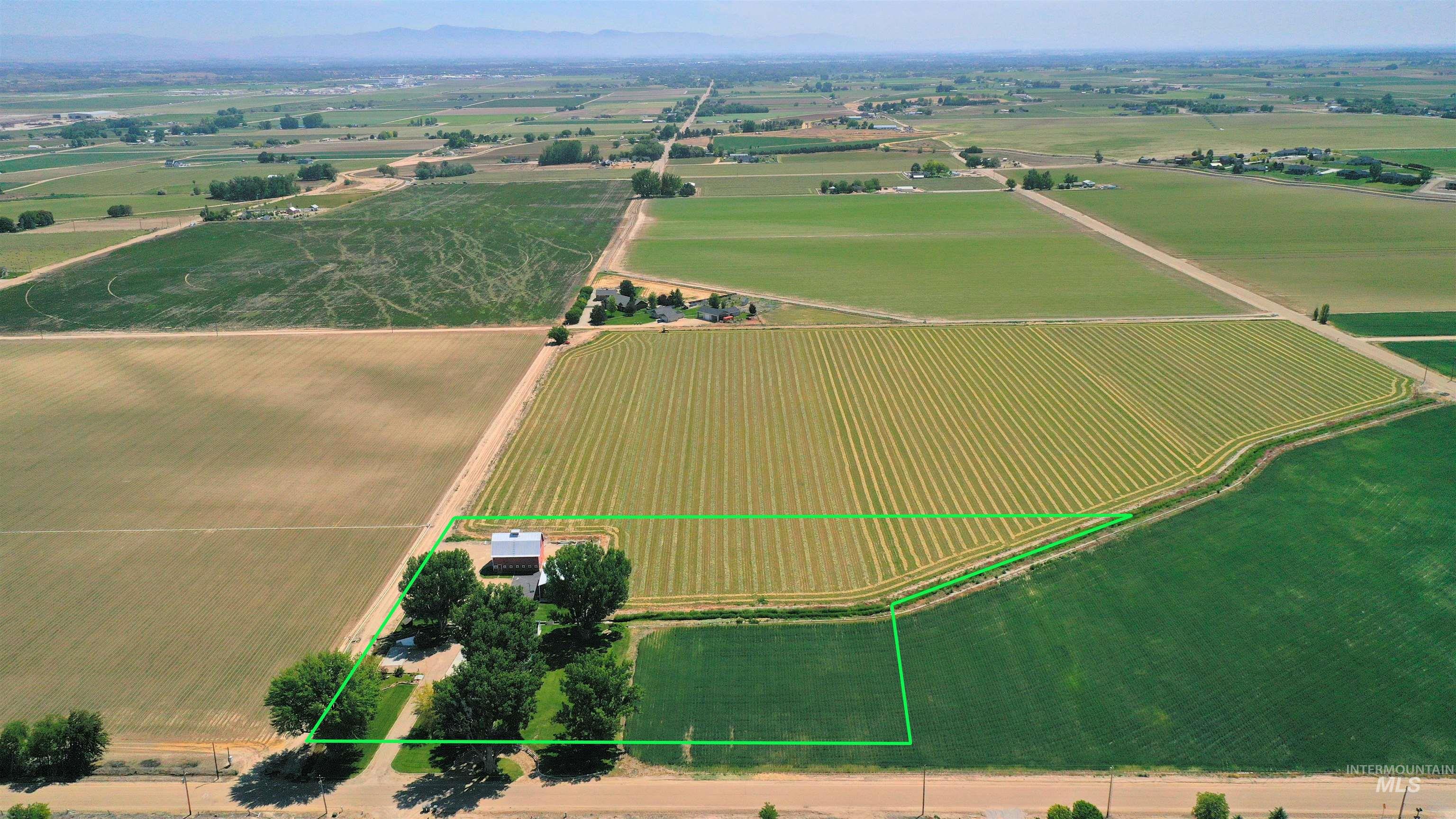 Aerial view of sparsely populated area with large plots for crops and property parcel outlined