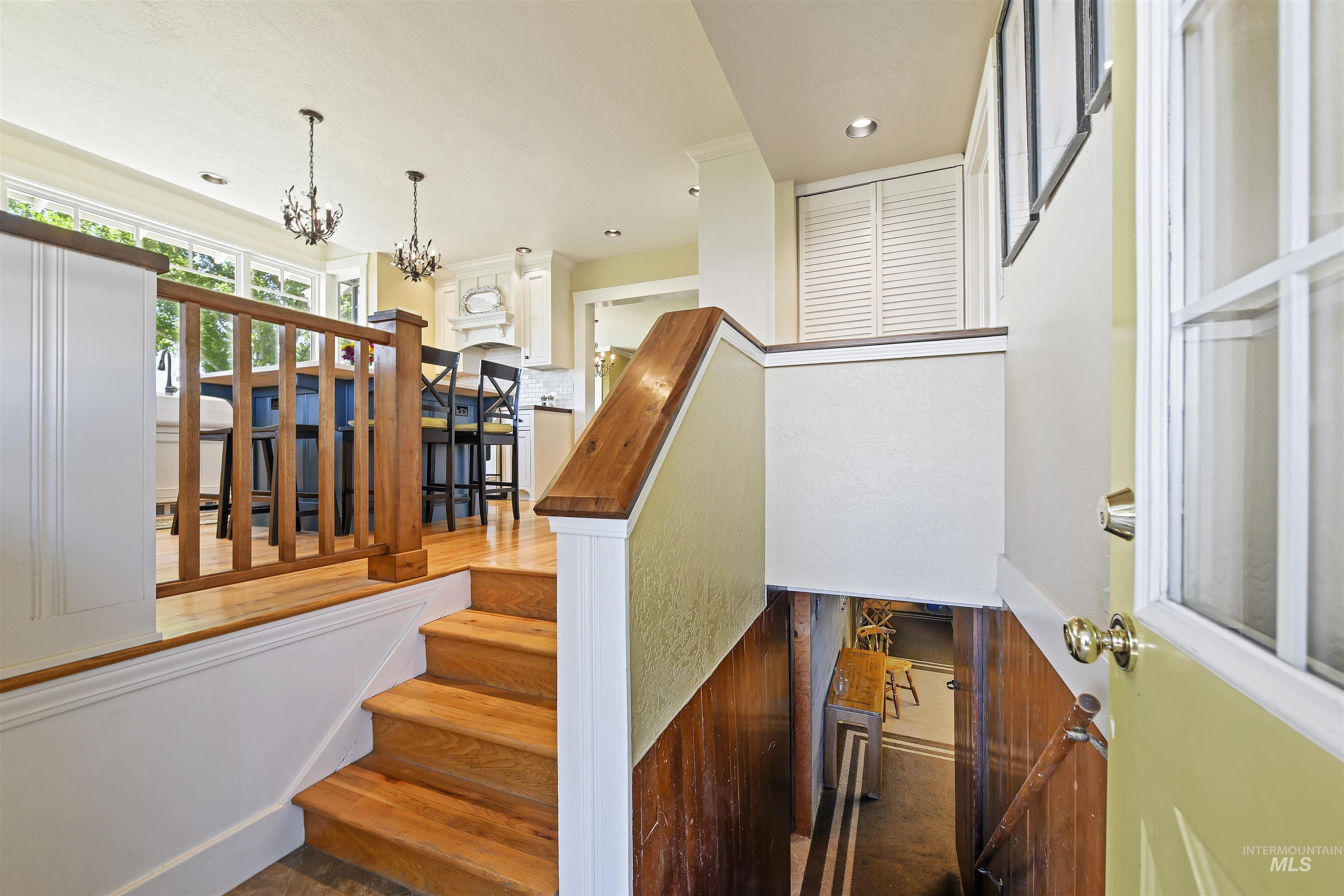 Stairs with wood finished floors, a chandelier, and recessed lighting