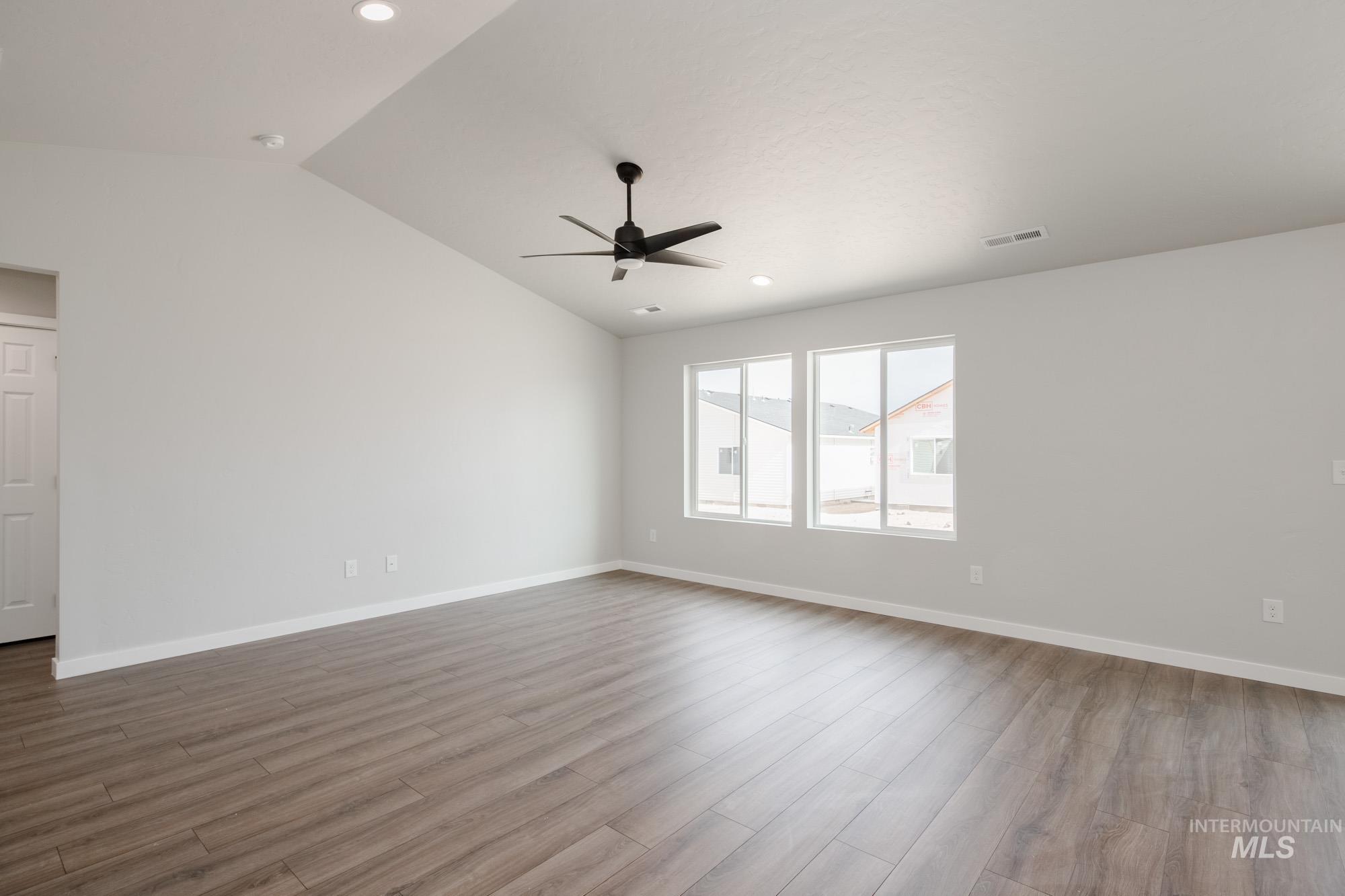 Empty room featuring vaulted ceiling, light wood-style flooring, recessed lighting, and ceiling fan