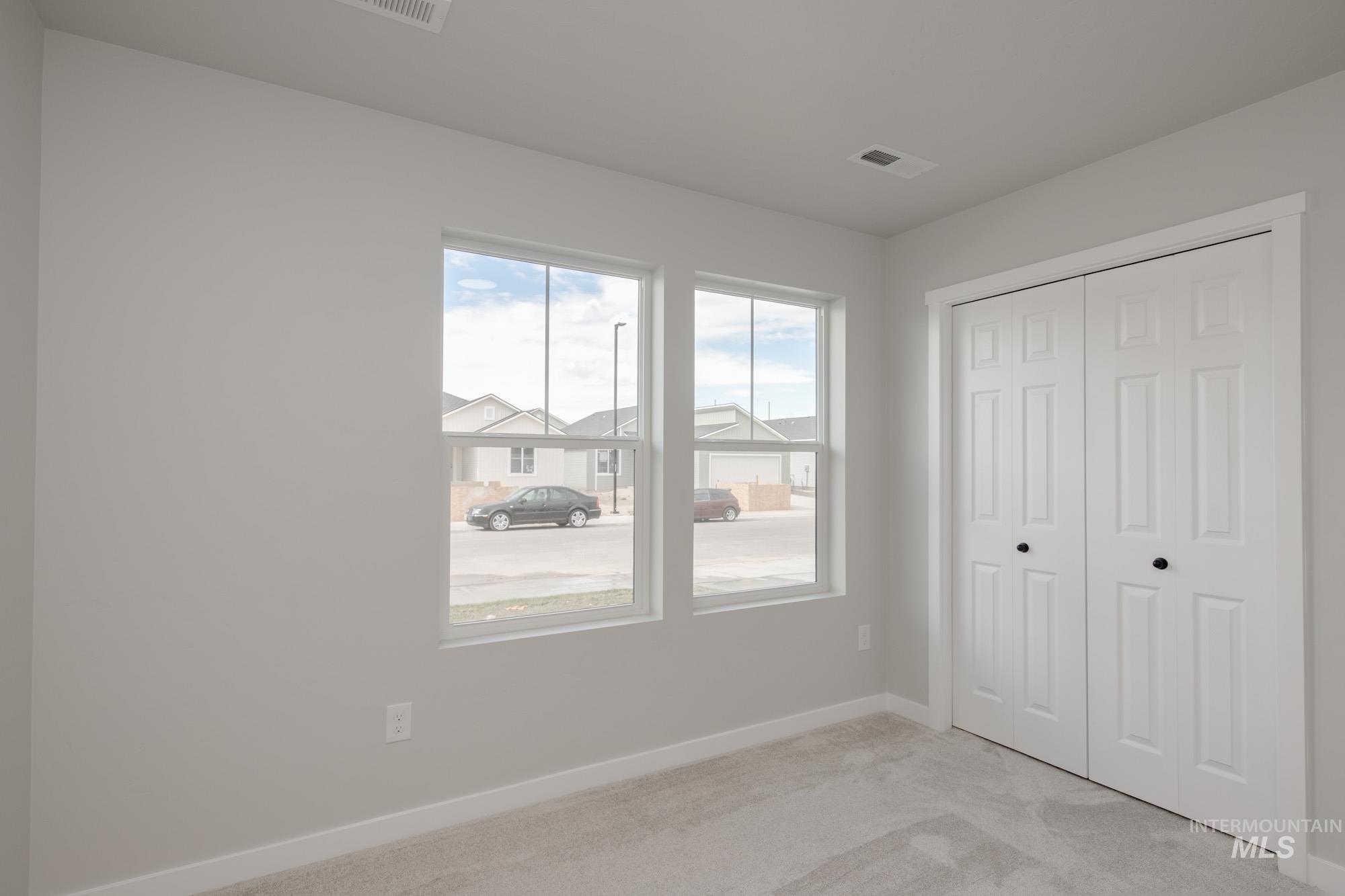 Unfurnished bedroom with light carpet and a closet