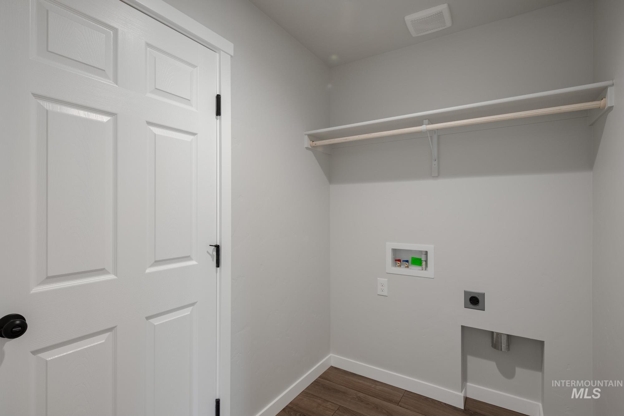 Laundry area with dark wood finished floors, hookup for an electric dryer, and washer hookup