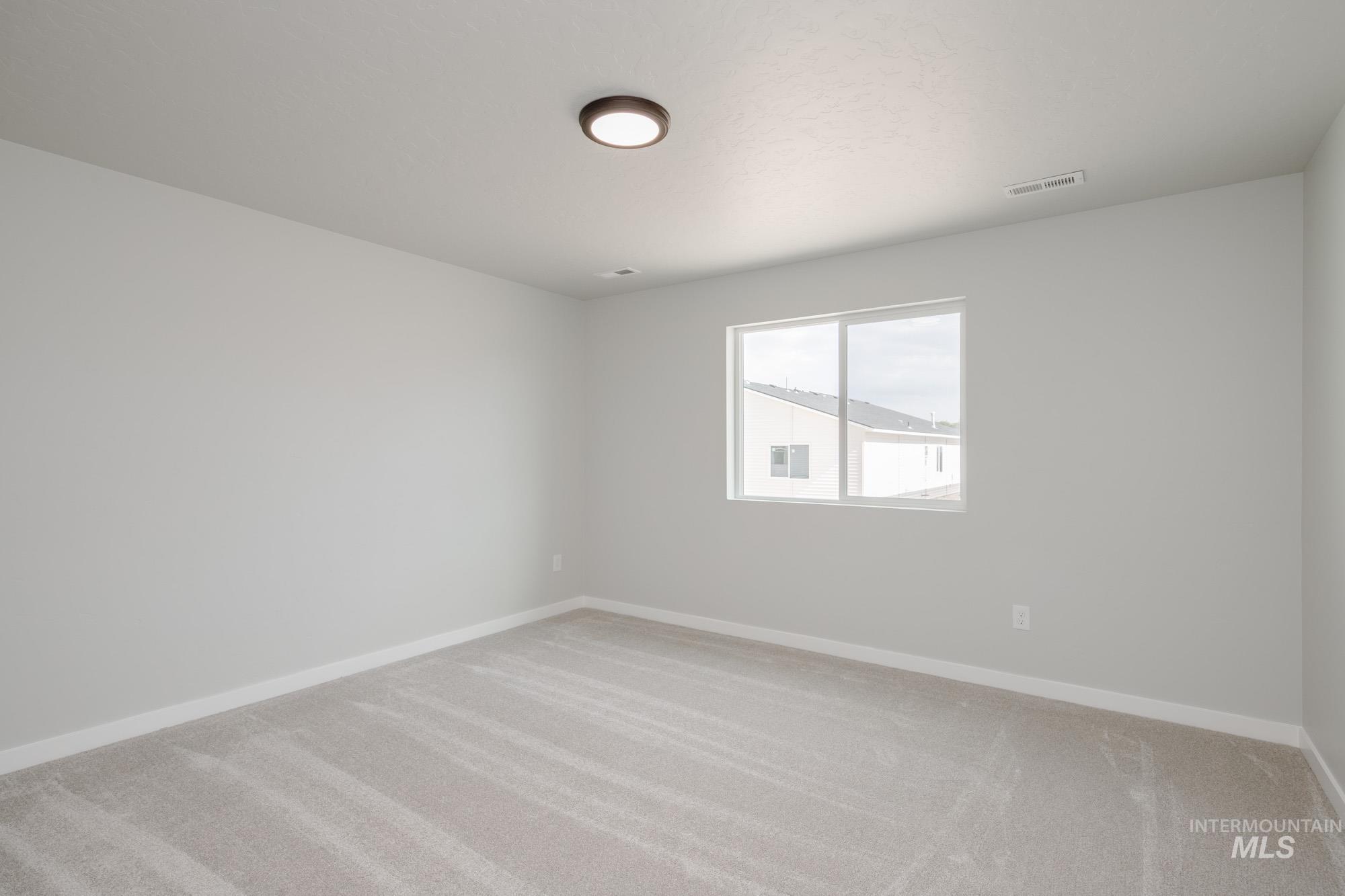 Empty room with light carpet and baseboards