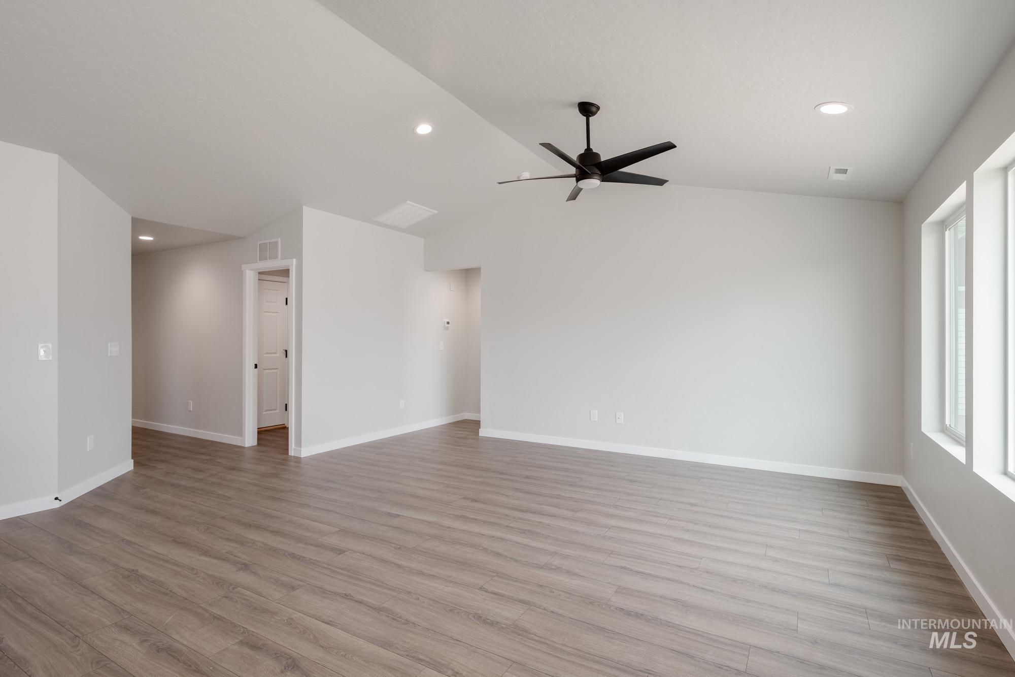 Unfurnished living room with recessed lighting, light wood finished floors, vaulted ceiling, and ceiling fan