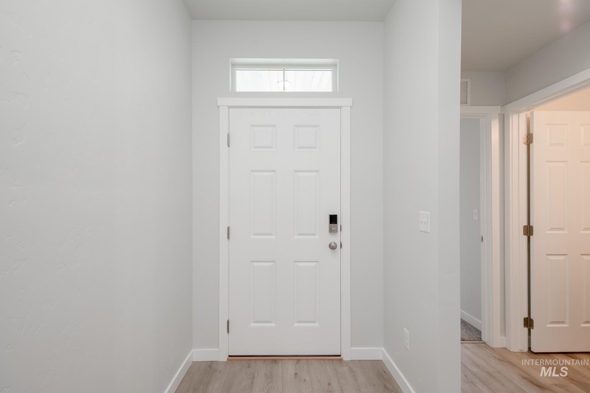 Foyer entrance with light wood-style flooring and baseboards