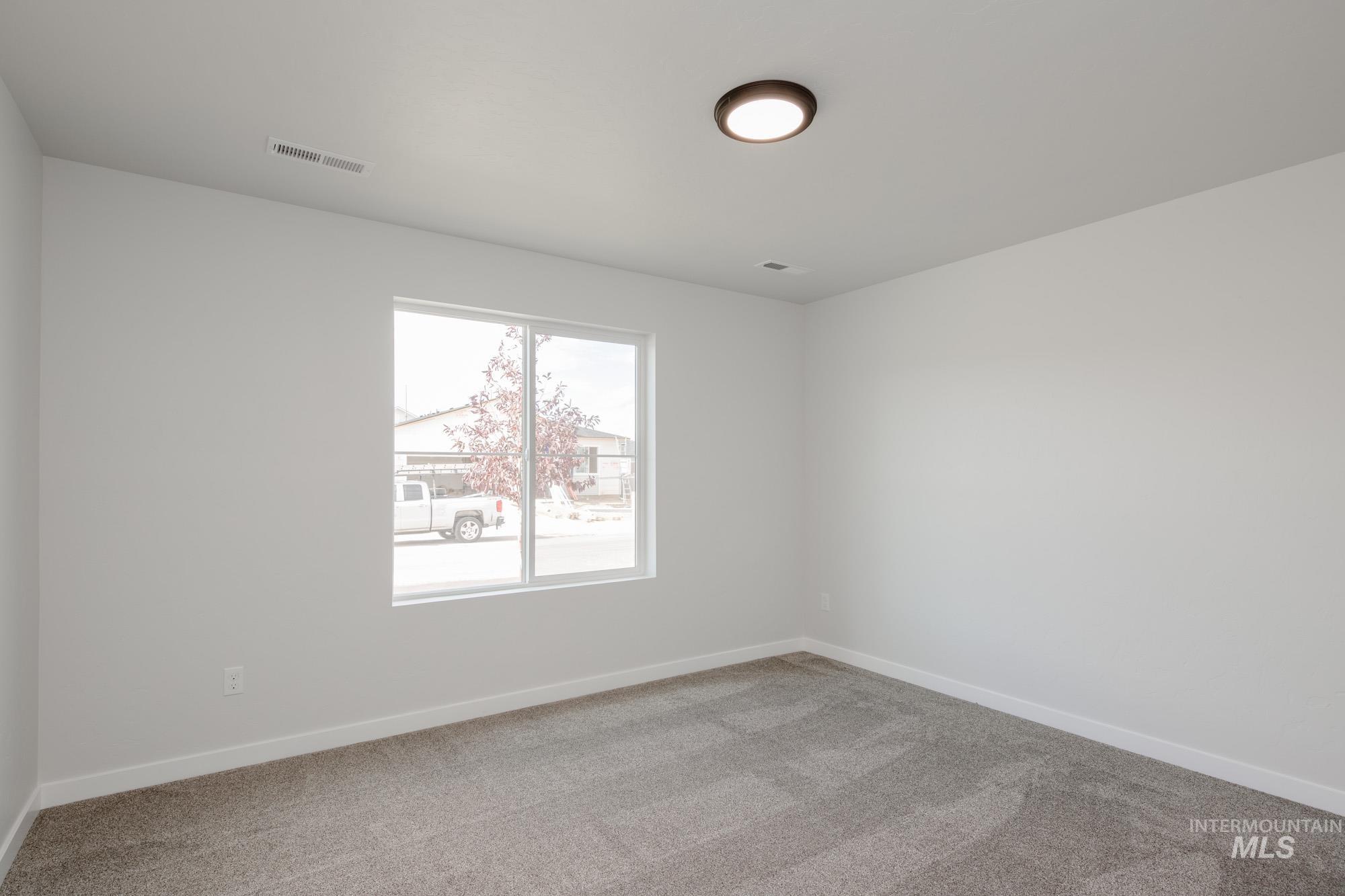 Spare room with light carpet and baseboards