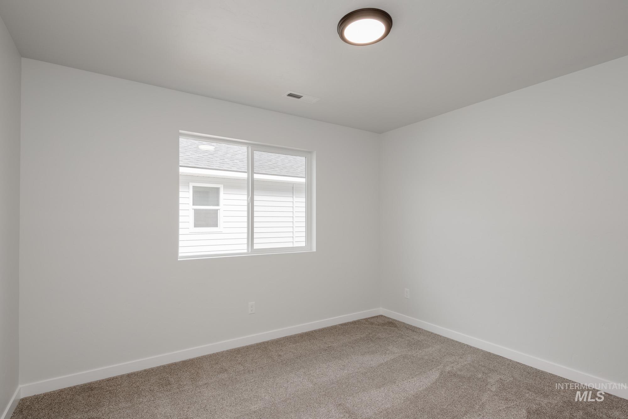 Carpeted spare room with baseboards