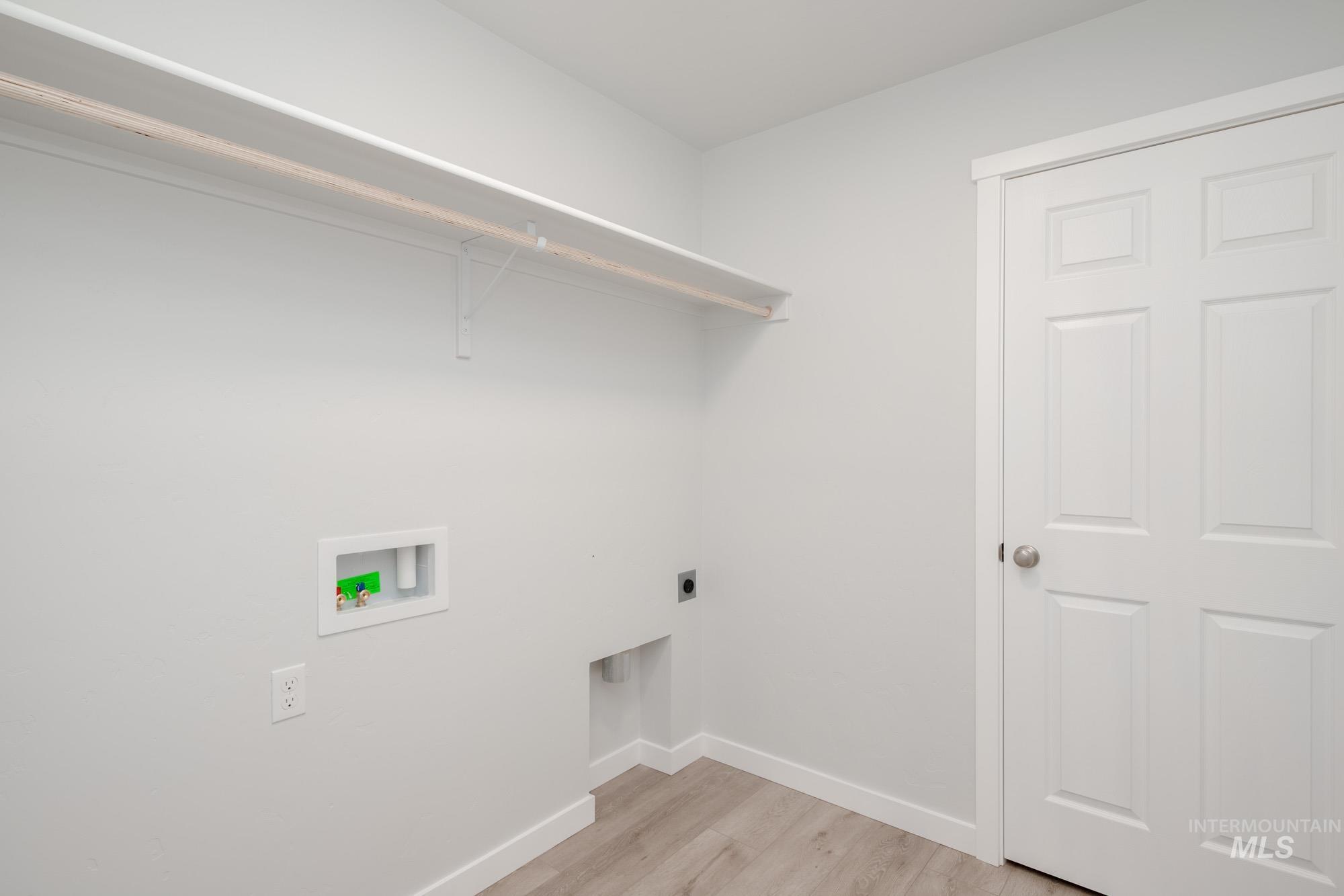 Washroom featuring light wood-style floors, electric dryer hookup, and hookup for a washing machine