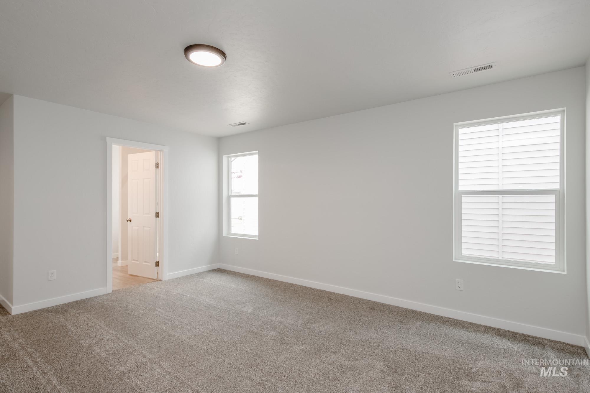 Spare room with light carpet and baseboards
