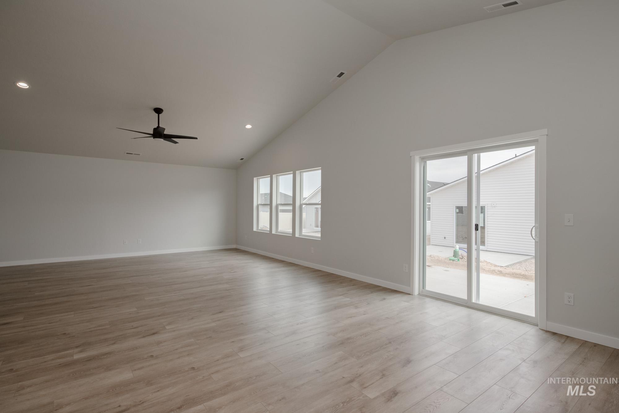 Unfurnished living room featuring high vaulted ceiling, light wood-type flooring, recessed lighting, and a ceiling fan