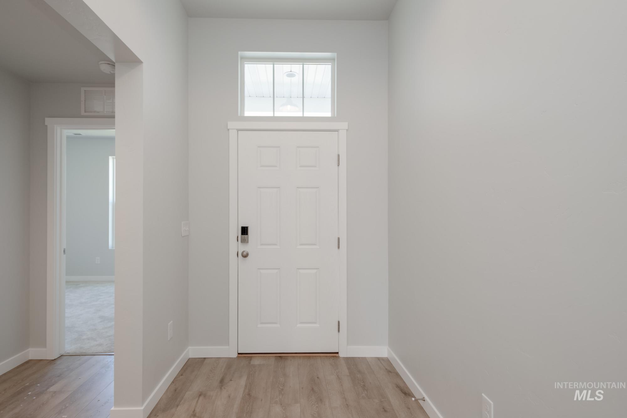 Entryway with baseboards and light wood-style floors