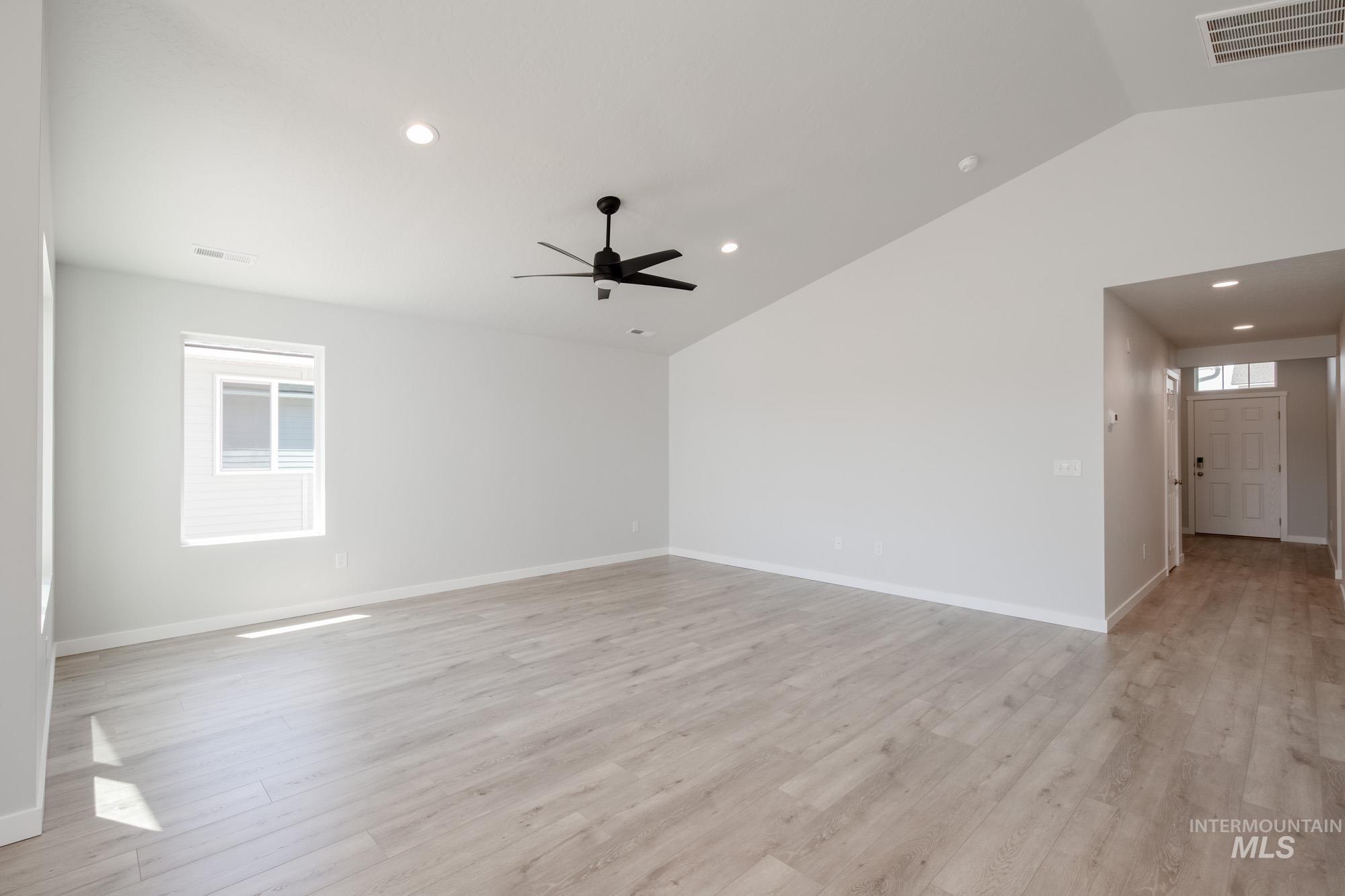 Unfurnished room featuring lofted ceiling, plenty of natural light, recessed lighting, light wood-type flooring, and ceiling fan