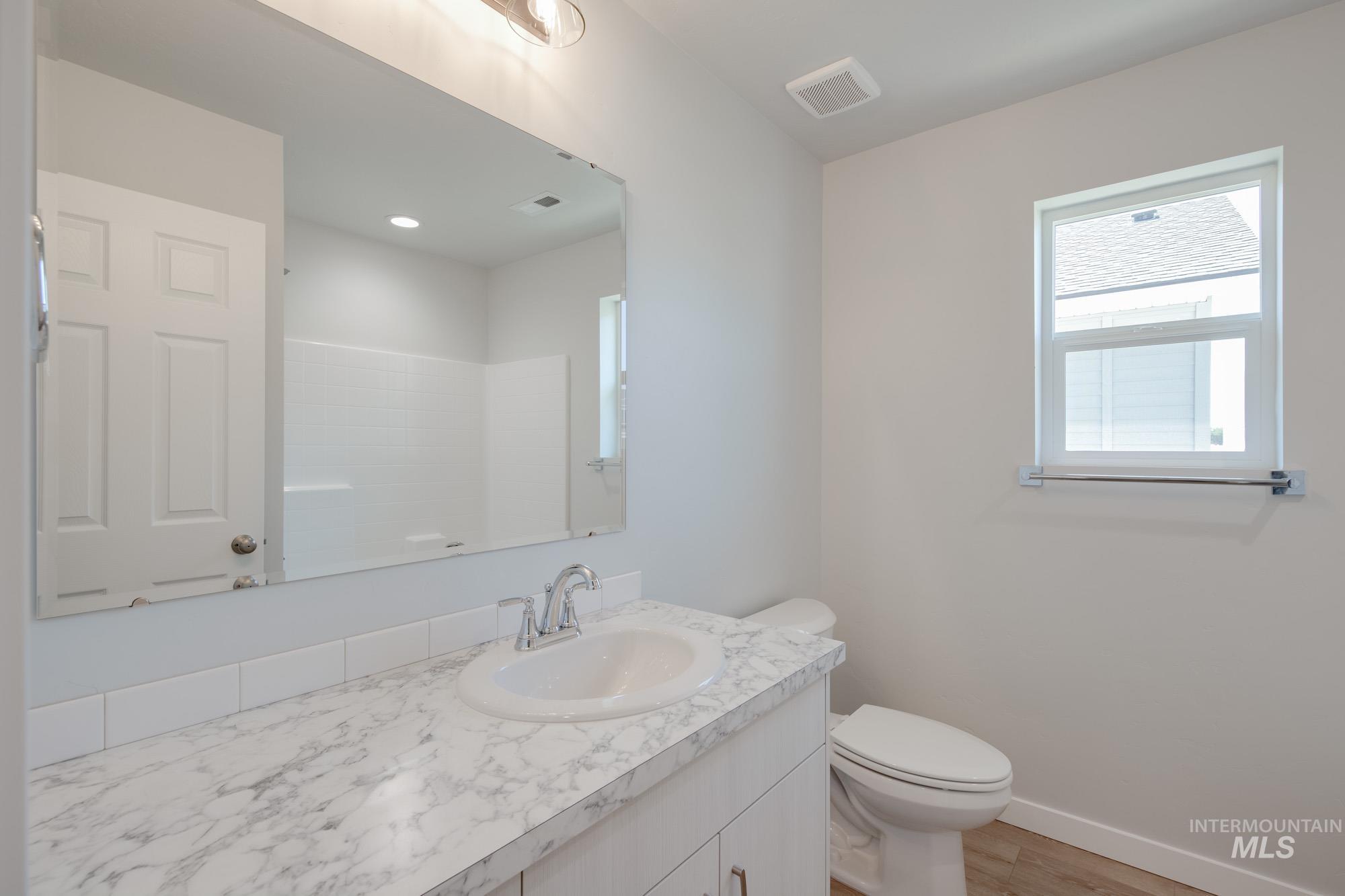 Full bath featuring vanity and light wood-type flooring