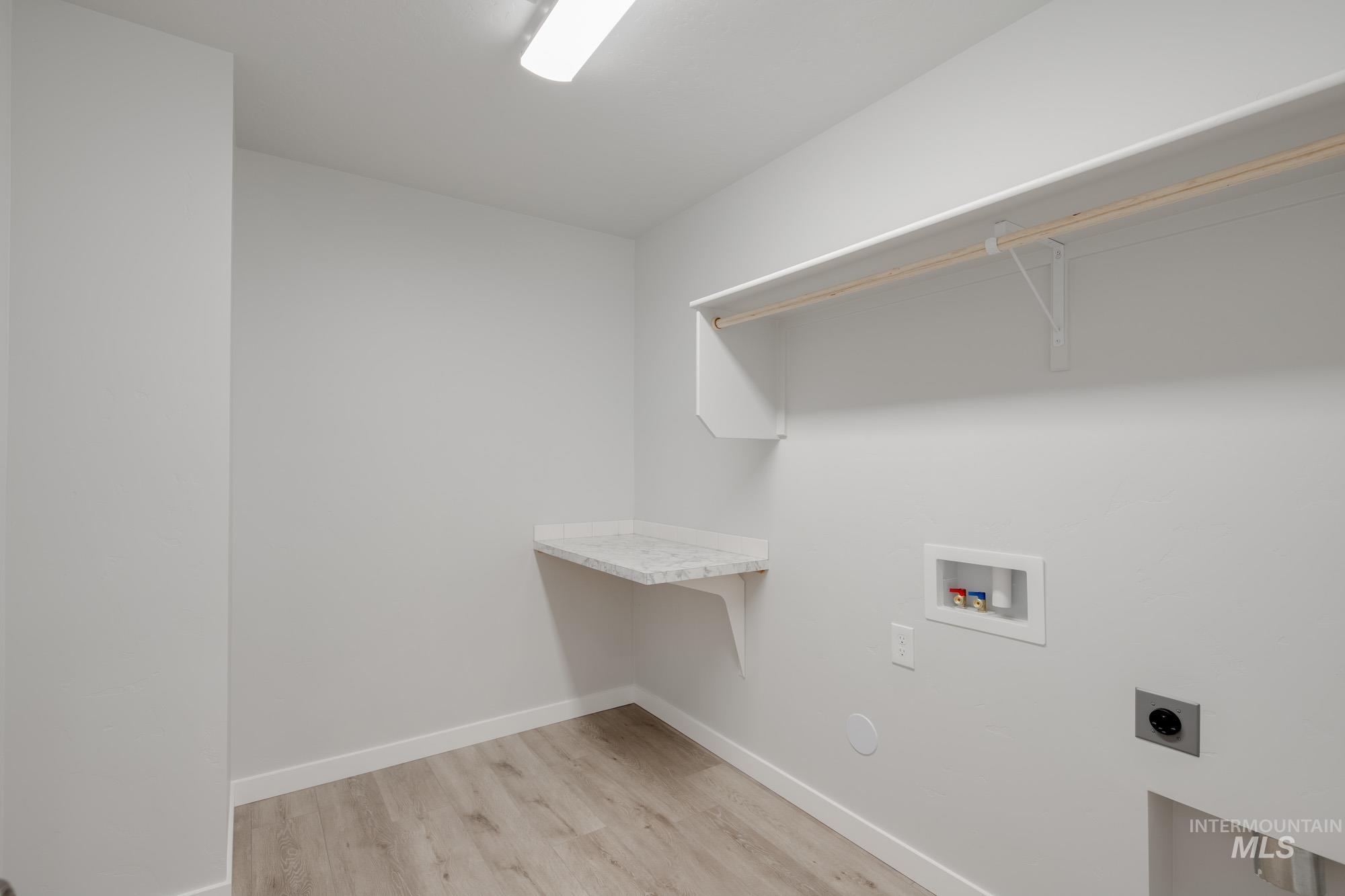 Laundry room featuring washer hookup, light wood-type flooring, and electric dryer hookup