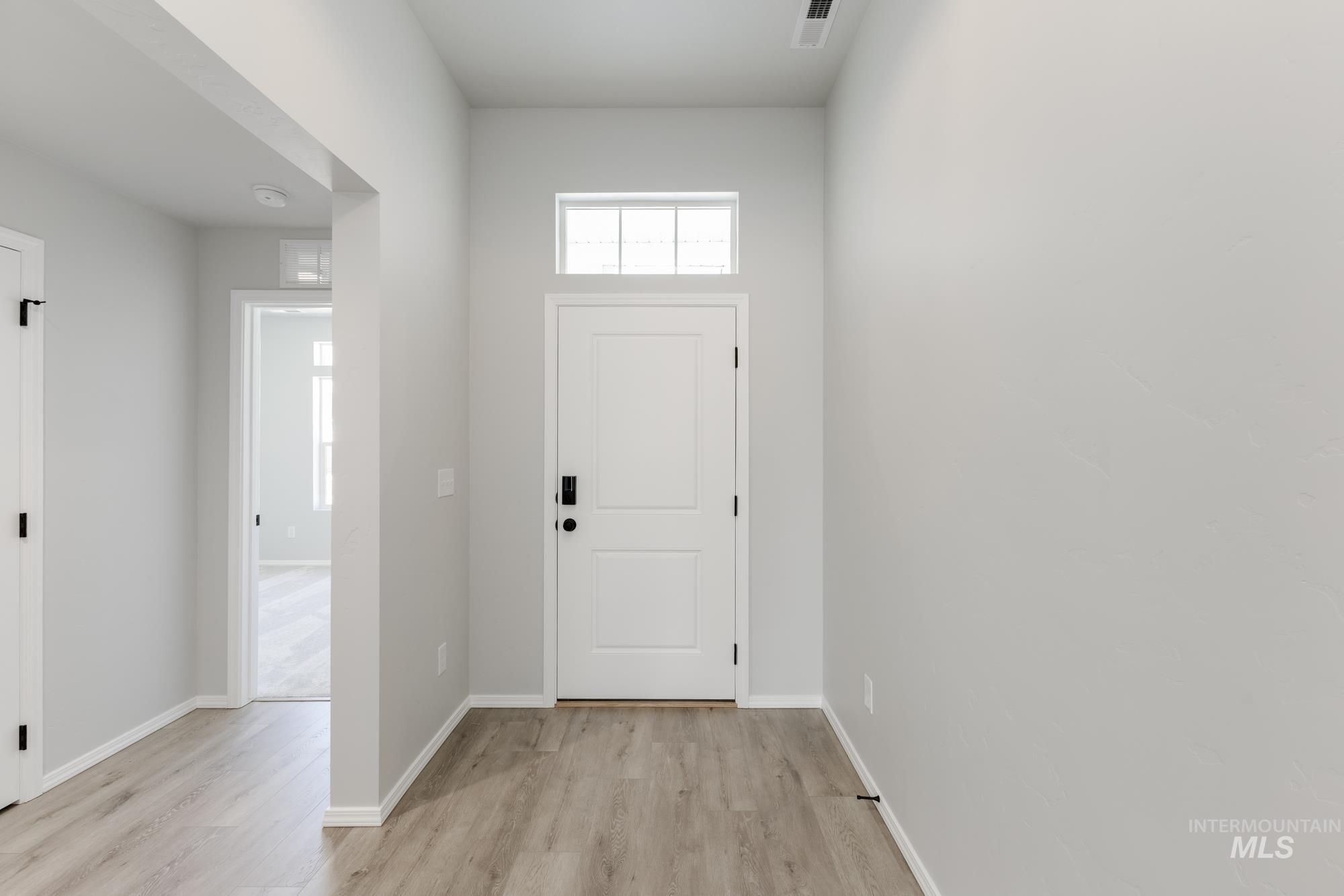 Entryway with baseboards and light wood finished floors
