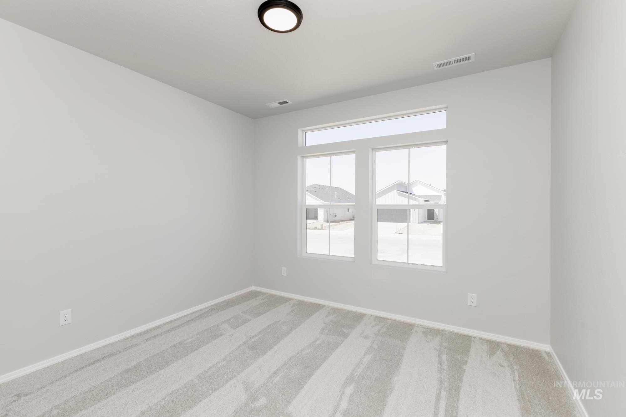 Empty room with carpet flooring and baseboards