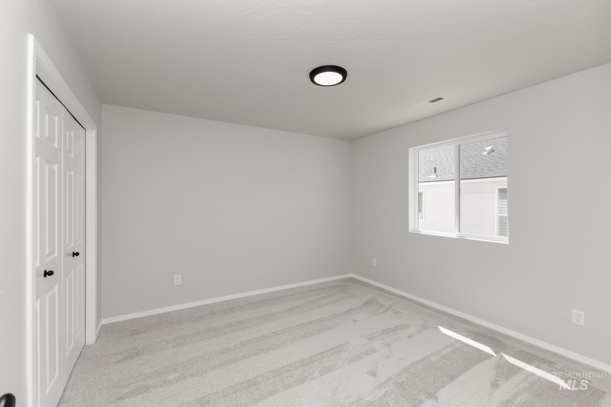 Unfurnished bedroom featuring light carpet and a closet