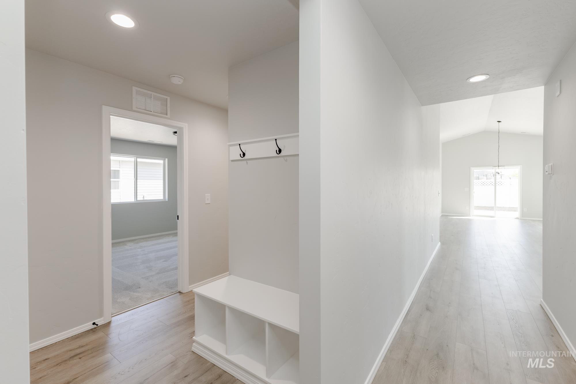Mudroom with healthy amount of natural light, light wood-style floors, a chandelier, recessed lighting, and lofted ceiling