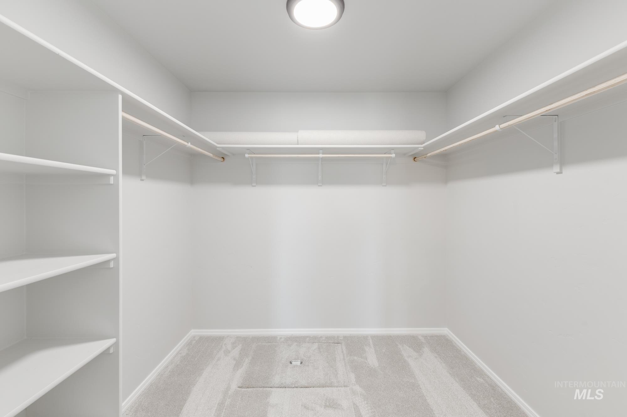 Spacious closet with light colored carpet