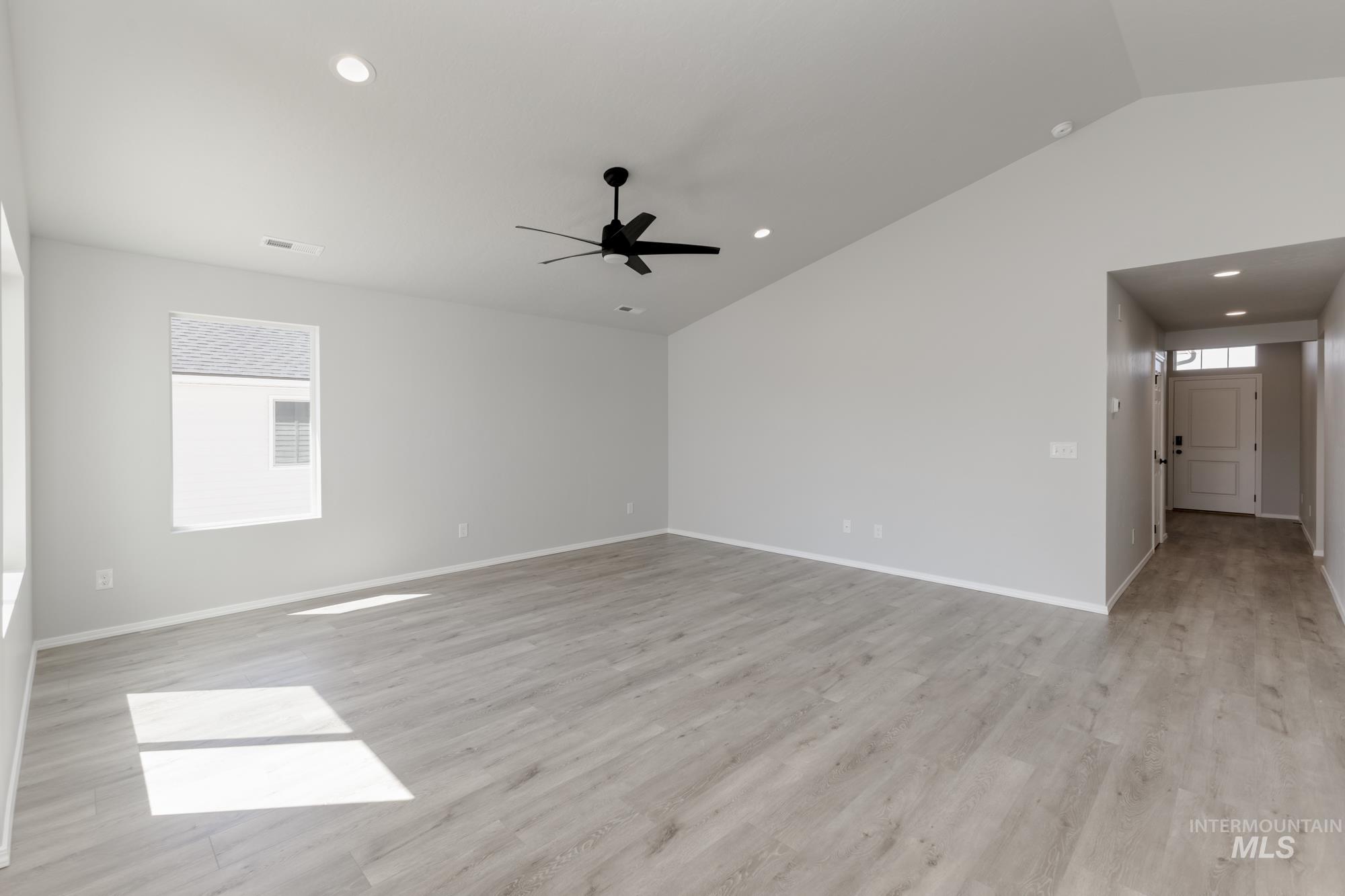 Unfurnished room featuring vaulted ceiling, light wood-style flooring, recessed lighting, and a ceiling fan