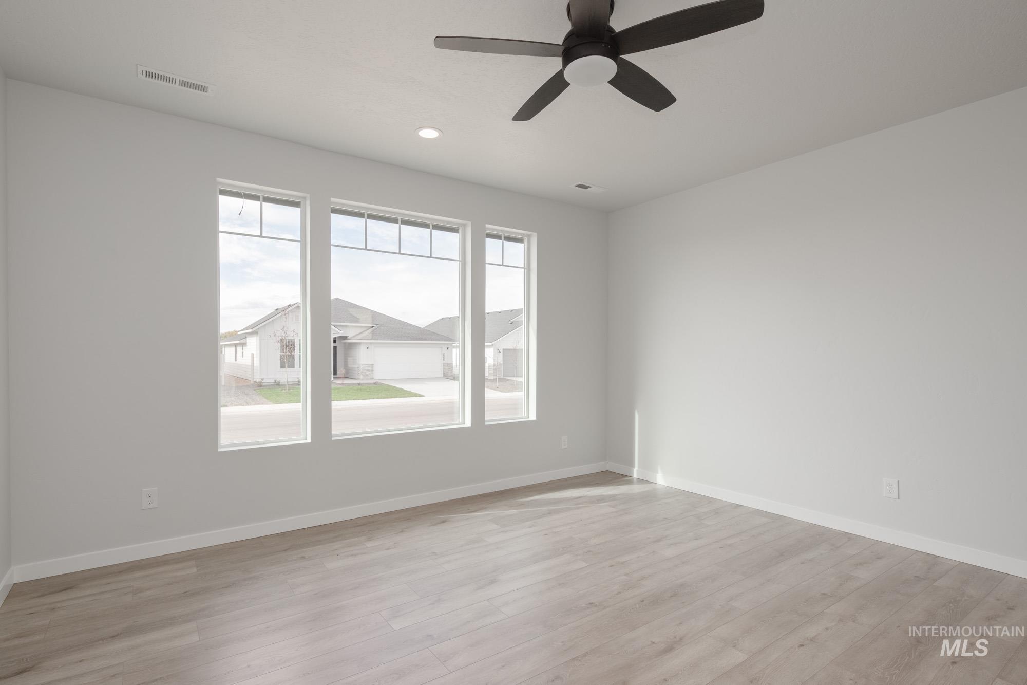 Unfurnished room featuring light wood finished floors, a ceiling fan, and recessed lighting