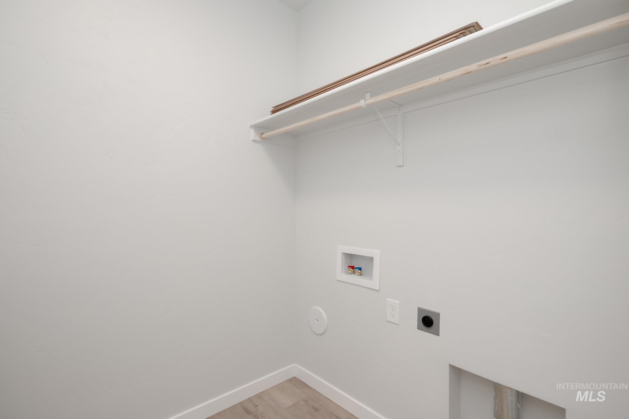 Laundry area featuring electric dryer hookup, washer hookup, and light wood-type flooring