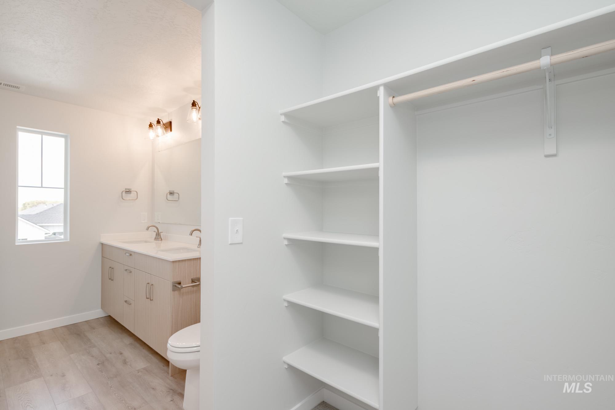 Bathroom with double vanity and light wood-style floors